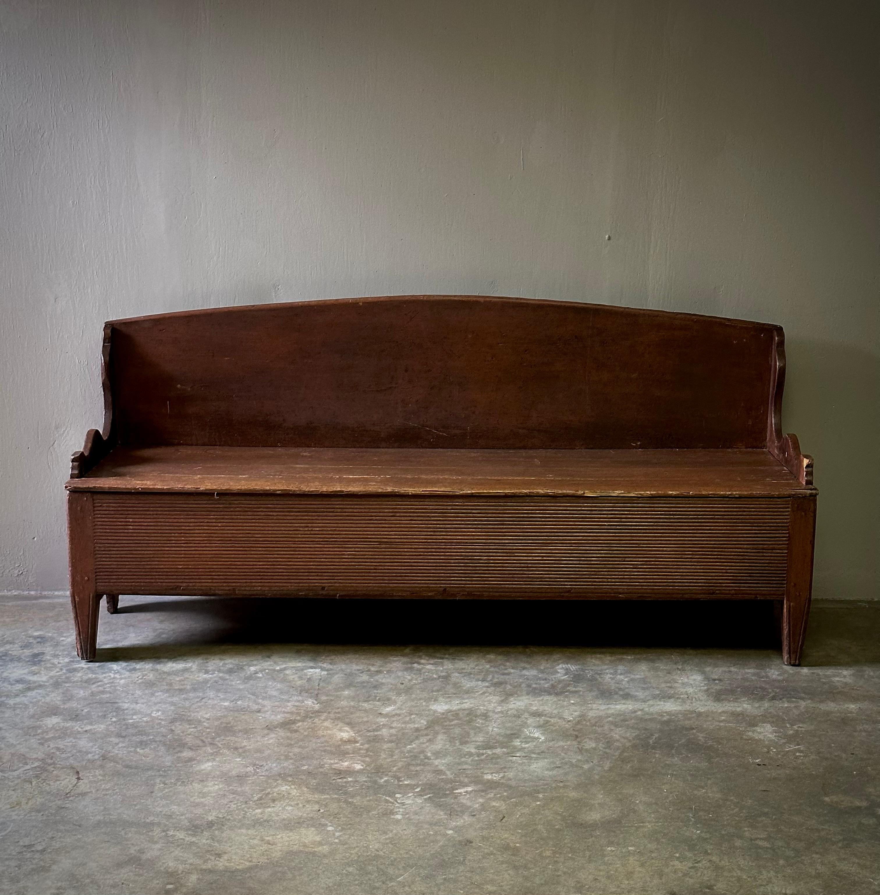 Rustic 19th century Swedish wooden hallway or patio bench. Humble yet capacious with a straight back, deep-set seat, ribbed accenting and hand carved armrests. Rustic simplicity at its best. 

Sweden, circa 1860

Dimensions: 72W x 21Dx 34.5H x