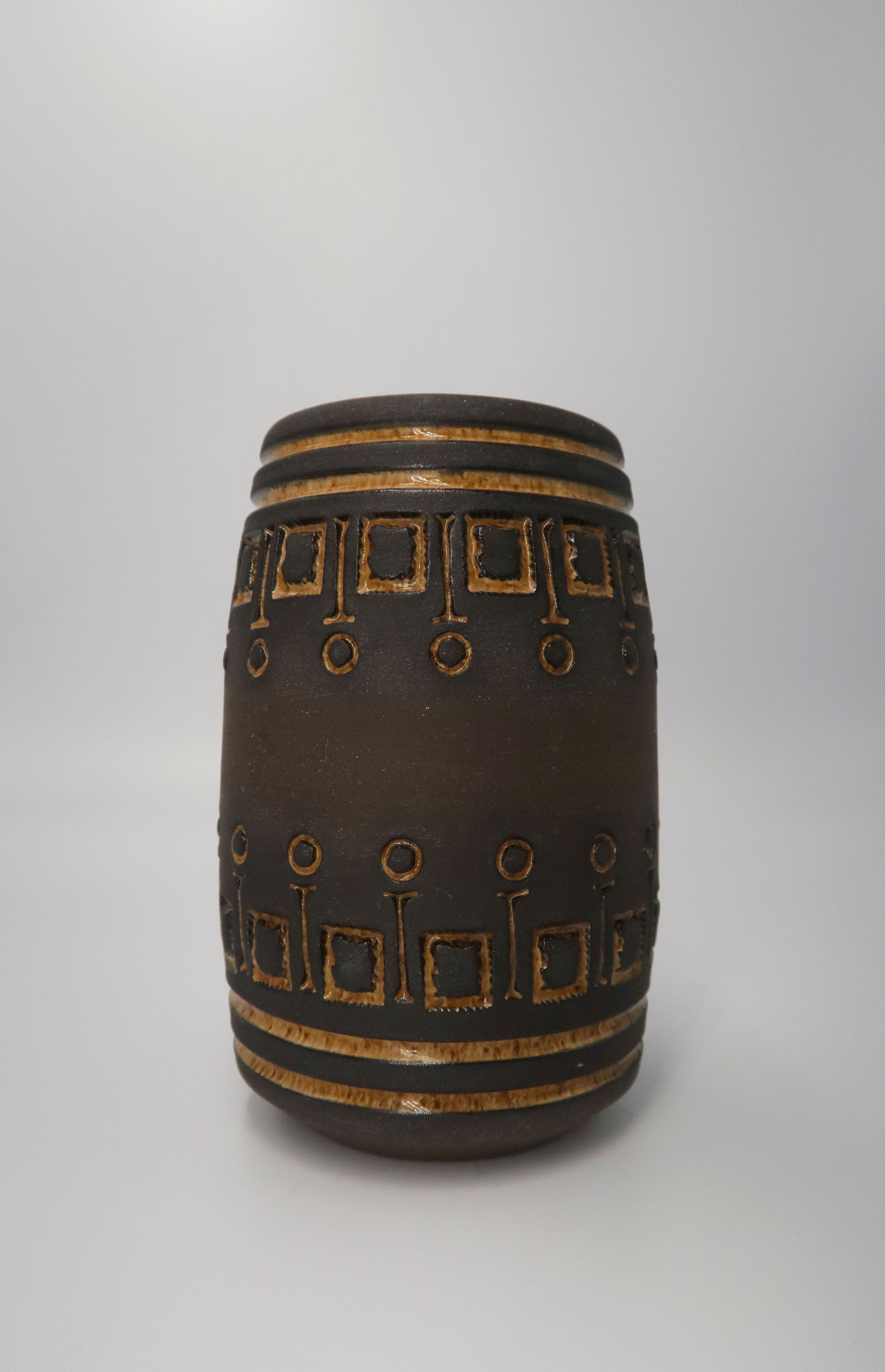 Beautiful rustic Scandinavian modern vase designed by Swedish ceramic artist Ulla Winblad in the early 1960s before she moved to Seattle. Raw hickory colored ceramic vase with golden geometric relief patterns etched and carved by hand. Golden glaze