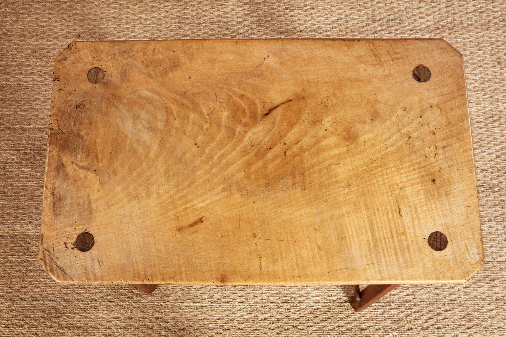 Petite table rustique en sycomore patiné à plateau épais rectangulaire reposant sur quatre pieds tournés et à ébrasement conique, avec des tenons traversants apparaissant sur la surface du plateau, reliés aux extrémités par des traverses. Anglais,
