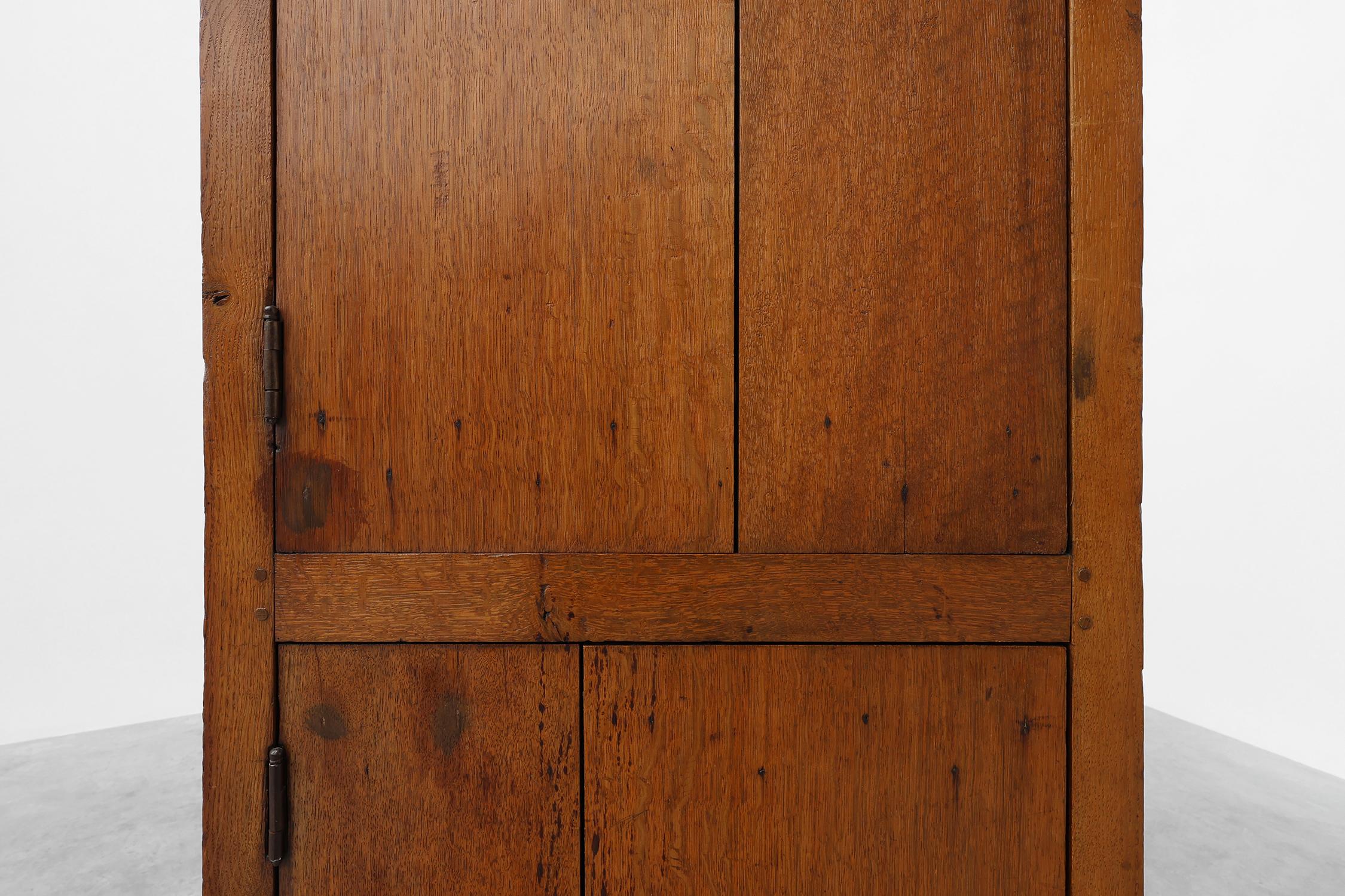 Precioso armario alto de monasterio, fabricado a mano en Francia a finales del siglo XIX. Este armario columna se fabricó con robusta madera de roble y tiene dos puertas y 6 estantes detrás, tres estantes por compartimento. Con su hermosa pátina y