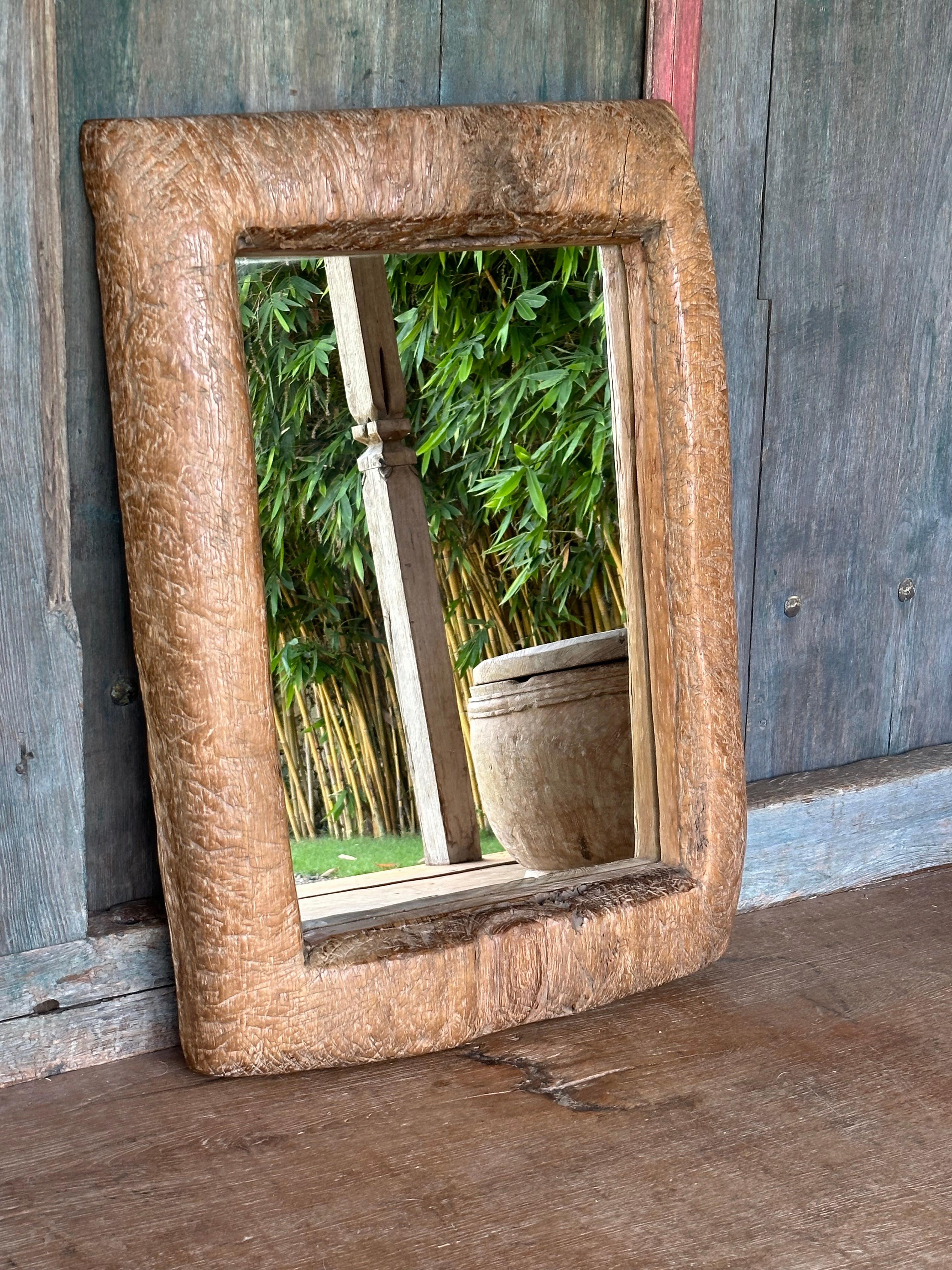 Ein wundervoller, einzigartiger Spiegel, der aus dem Holz einer antiken, massiven Teakholz-Lesung gefertigt wurde. Lesungs sind Reismörser, die auf der Insel Java zum Entfernen von Reishülsen verwendet werden. Das für diesen Spiegel verwendete Holz