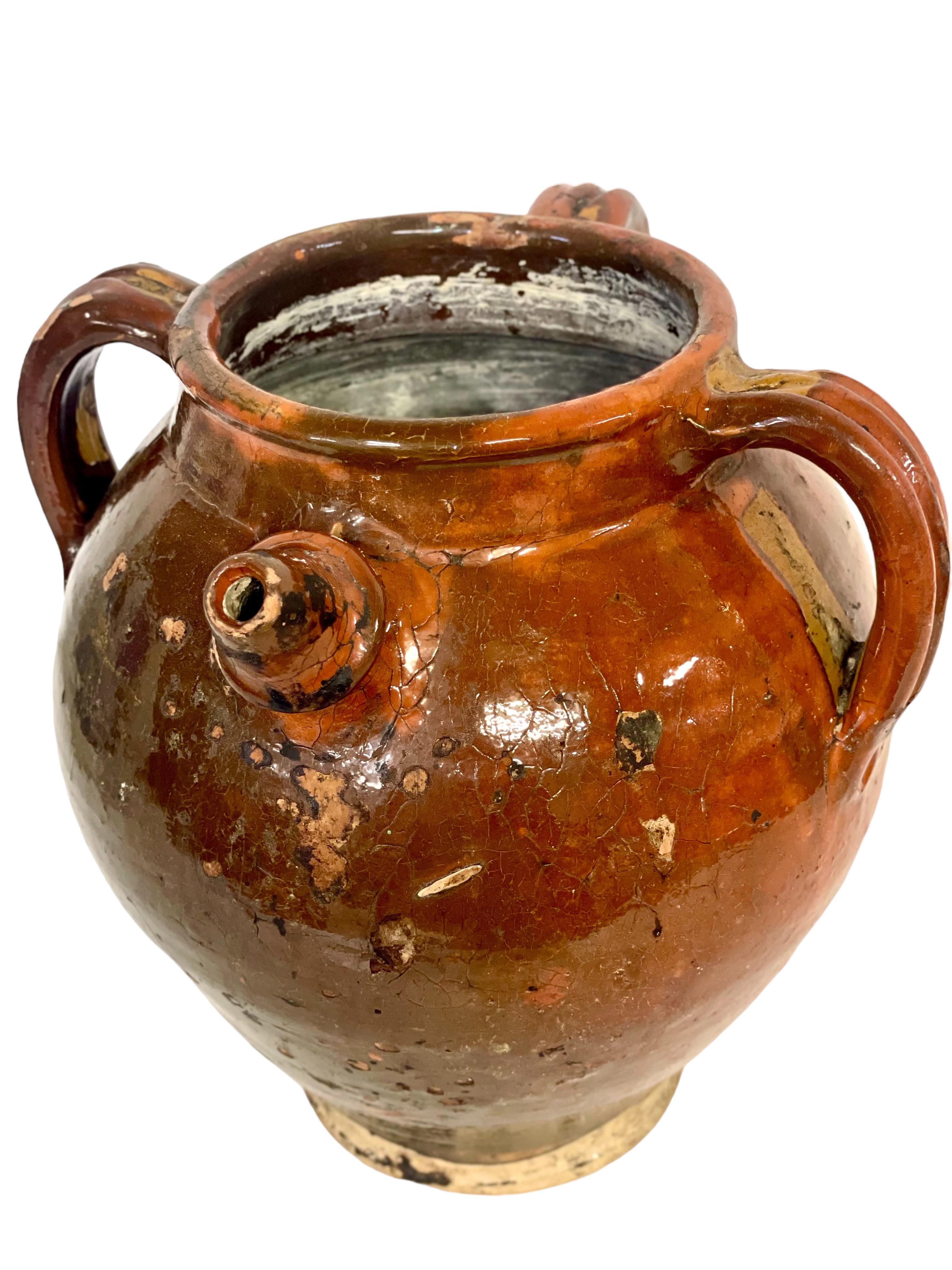 A gorgeous 19th century water, or olive oil, jug, glazed, inside and out in warm rustic tones of brown and green. Full of character, this unusual storage vessel features a short and shaped spout and three substantial upper handles around its rim to