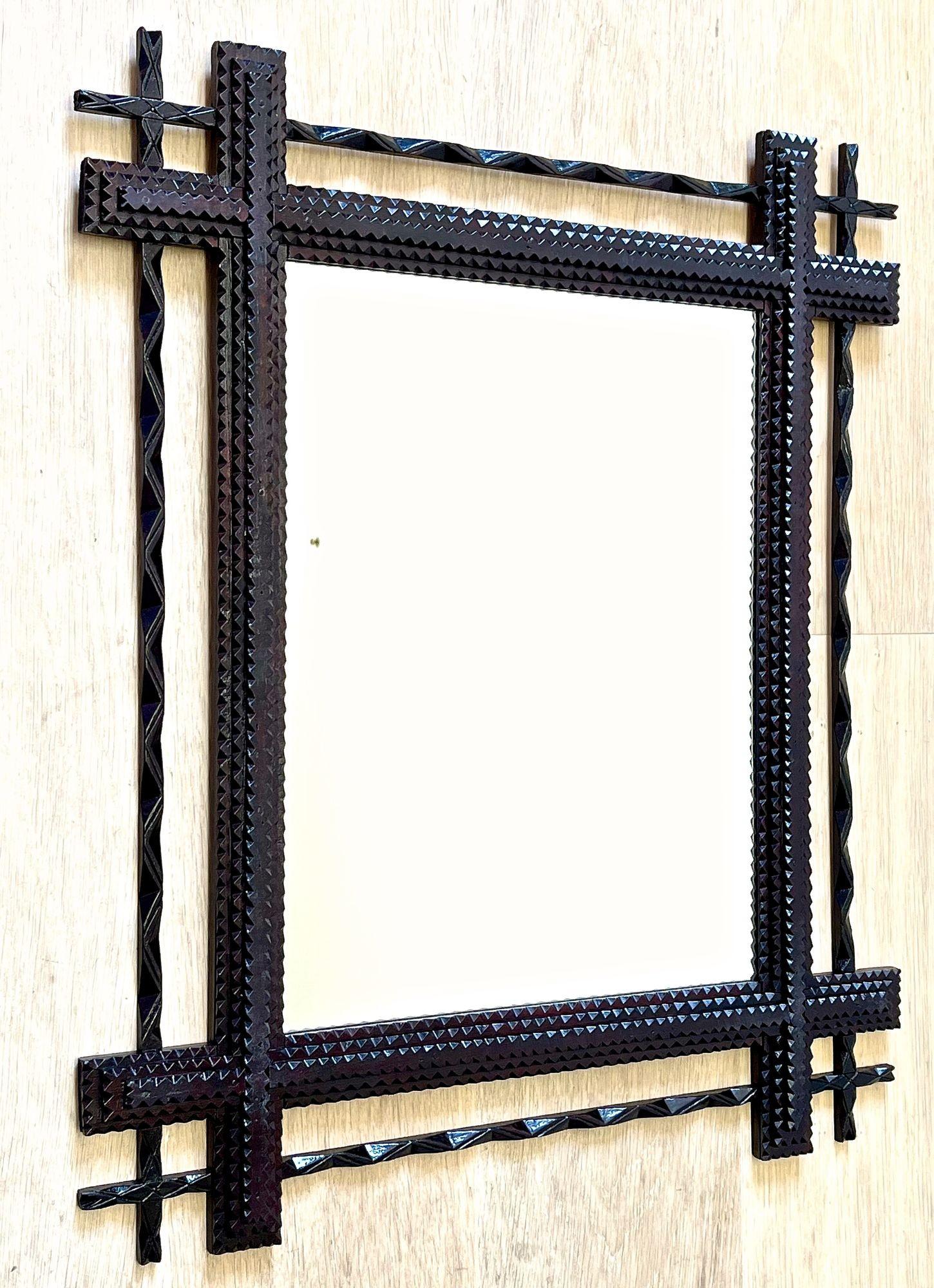 Extraordinary rustic Tramp Art mirror from the late 19th century in Austria around 1890. This wooden wall mirror has been effortfully hand carved out of basswood and comes with a dark brown stained surface in great original condition. Highlighted