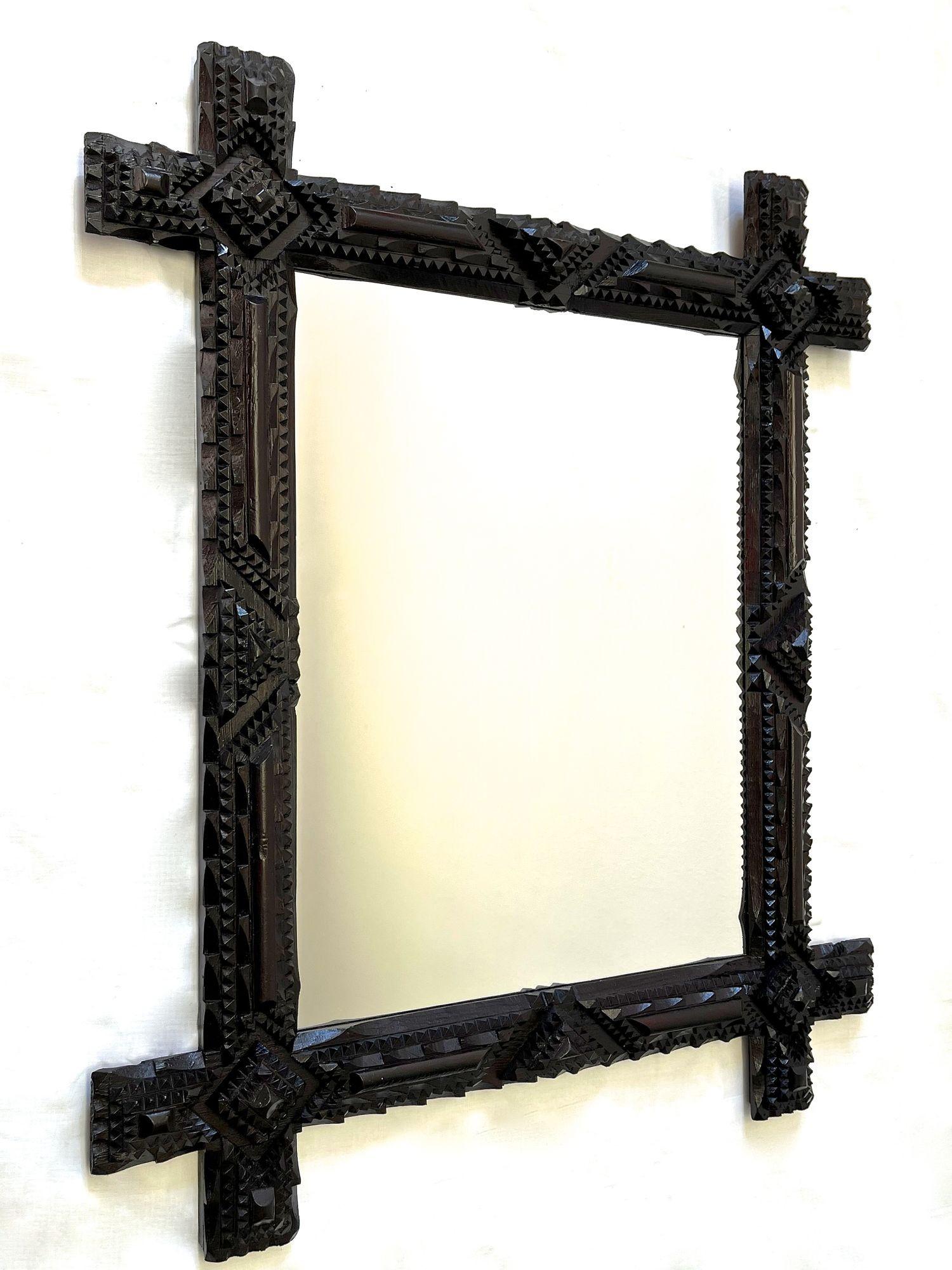 One of a kind handcarved Tramp Art wall mirror from the late 19th century in Austria. This elaborately made rustic mirror from around 1890 impresses with its fantastic set variety of different carvings. The resulting, amazing looking patterns in