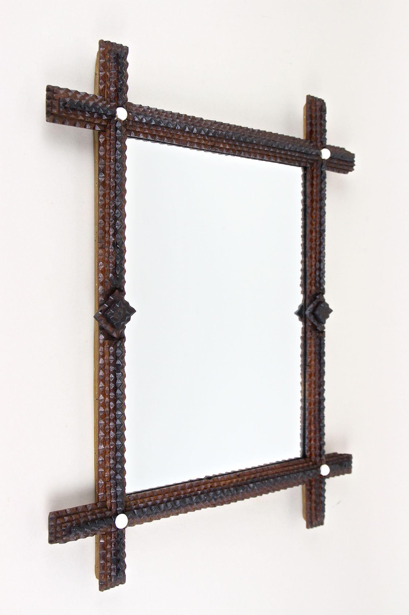 Extraordinary rustic hand carved Tramp Art wall mirror from the late 19th century around 1870 in Austria. Artfully crafted out of basswood, this fantastic looking, pretty old wall mirror shows the famous 