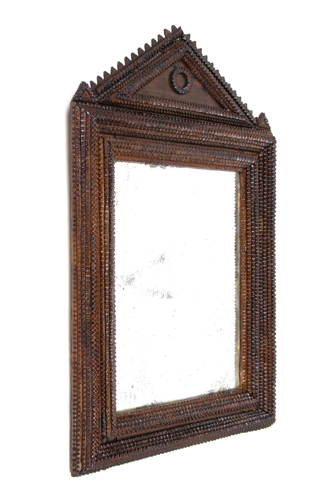 Very old, rare example of a hand-carved tramp art wall mirror, elaborately made in Austria in the period around 1860. Handcrafted from basswood, this detailed Tramp Art mirror was done in the so called 
