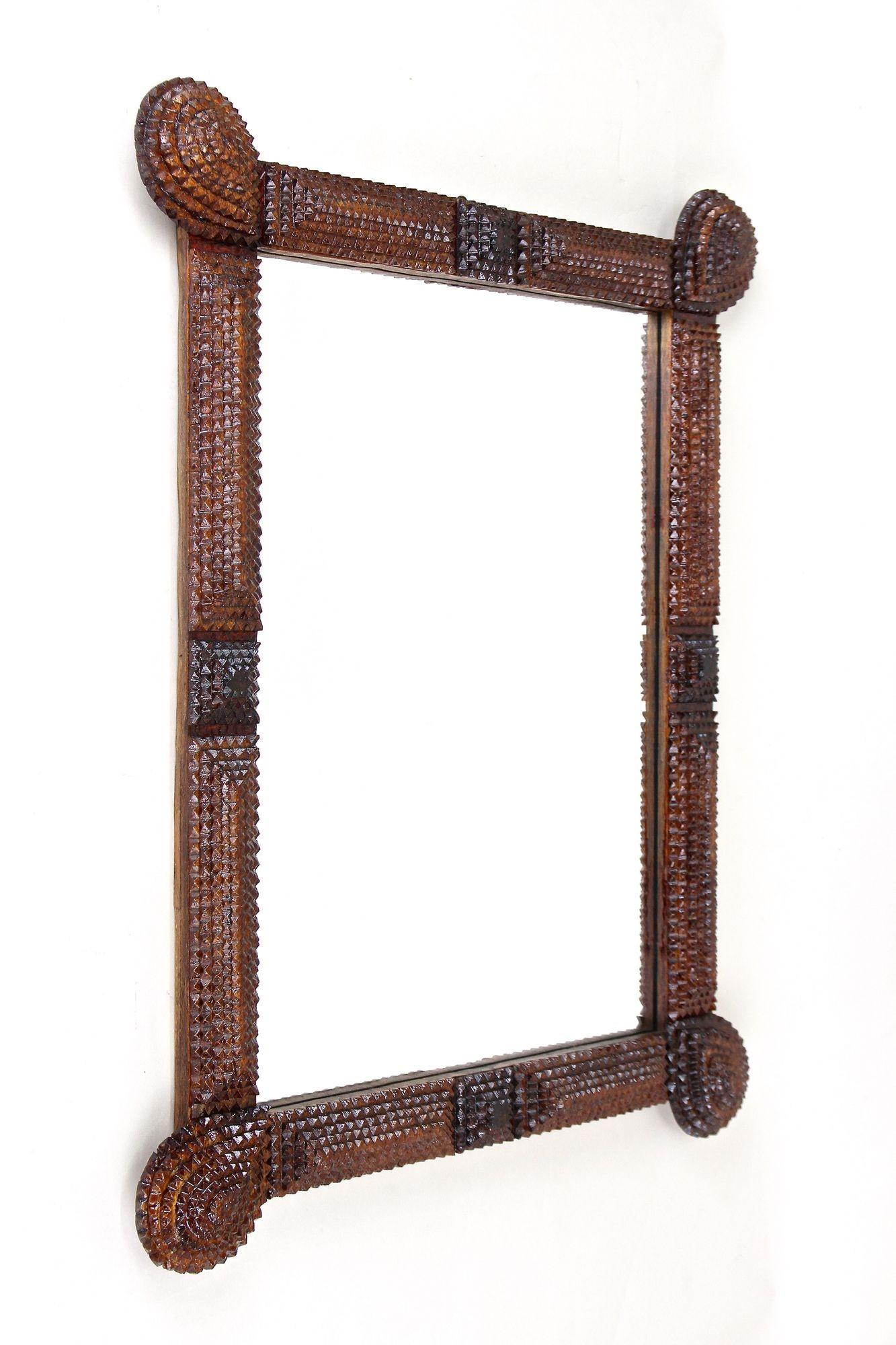 Extraordinary, unique rustic Tramp Art wall mirror out of Austria from the late 19th century around 1880. Artfully designed and handcarved out of basswood this very special Tramp Art work was crafted in the so called 