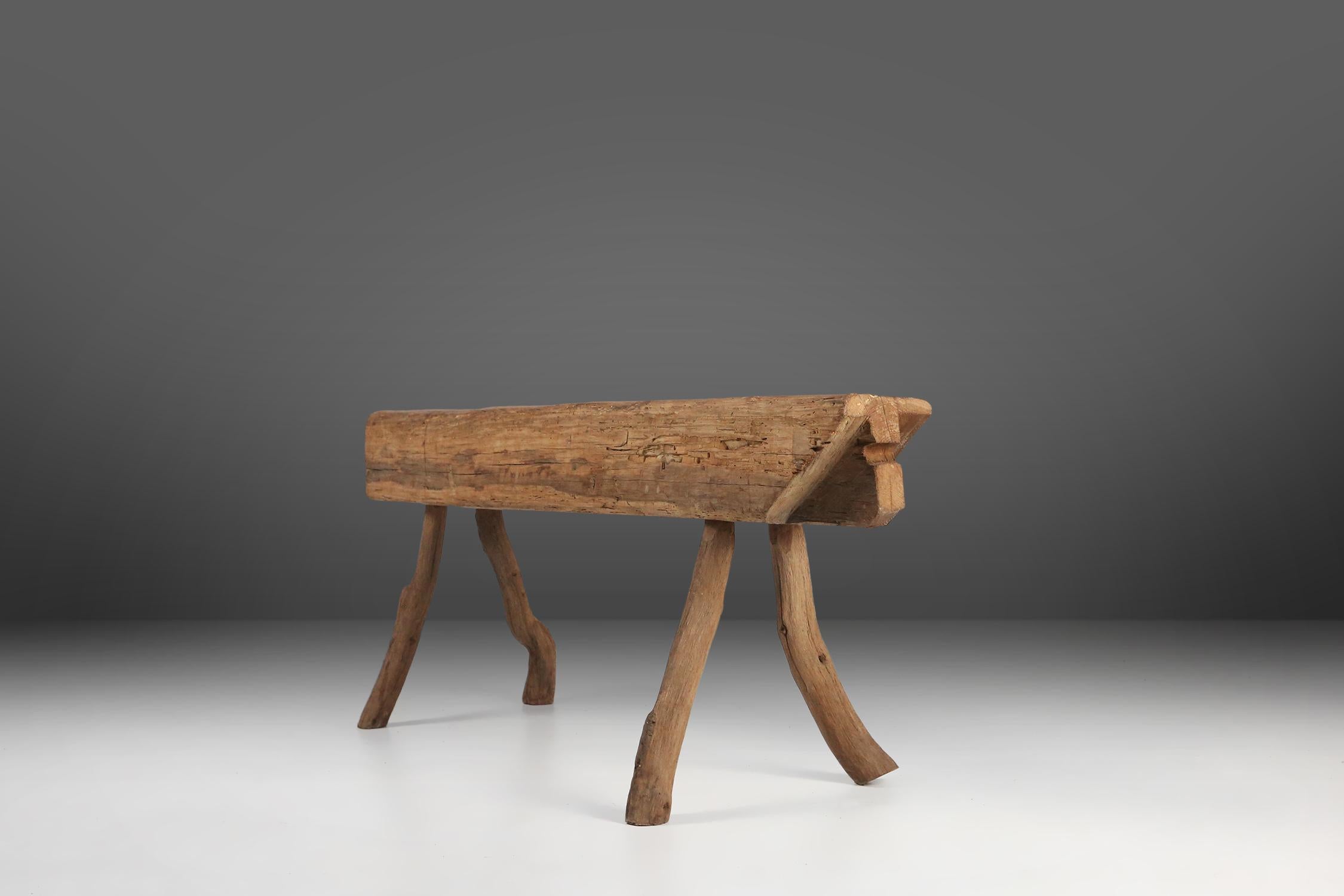 Remarkable antique wooden tree trunk bench crafted in France in 1850s. Made from a solid tree trunk, this bench is a testament to natural beauty and durability of wood.   The design of this wooden bench is both simple and captivating. Its legs are