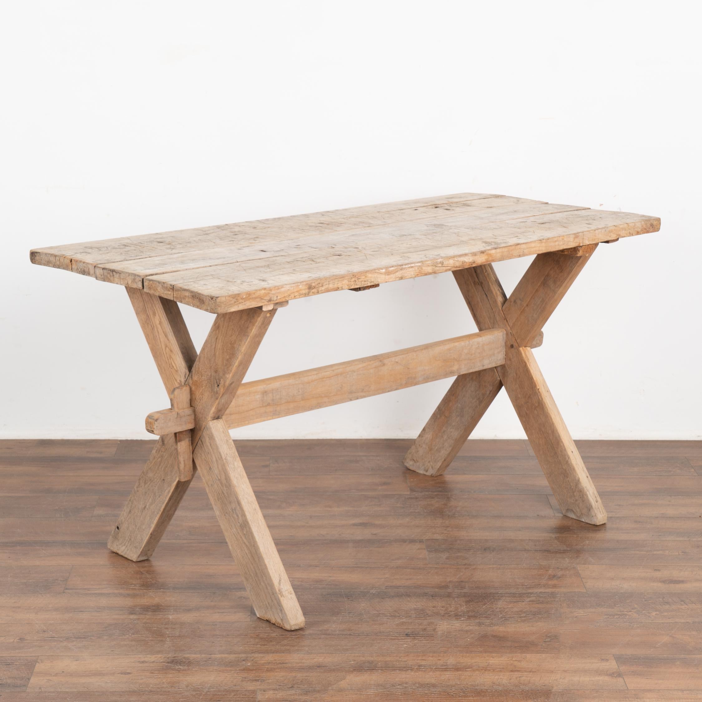 This farmhouse kitchen table has European country charm thanks to the unique X-stretcher base.
The natural wood has been distressed through generations of use, adding depth to the character of the table. The many scratches, dings, gougest, stains