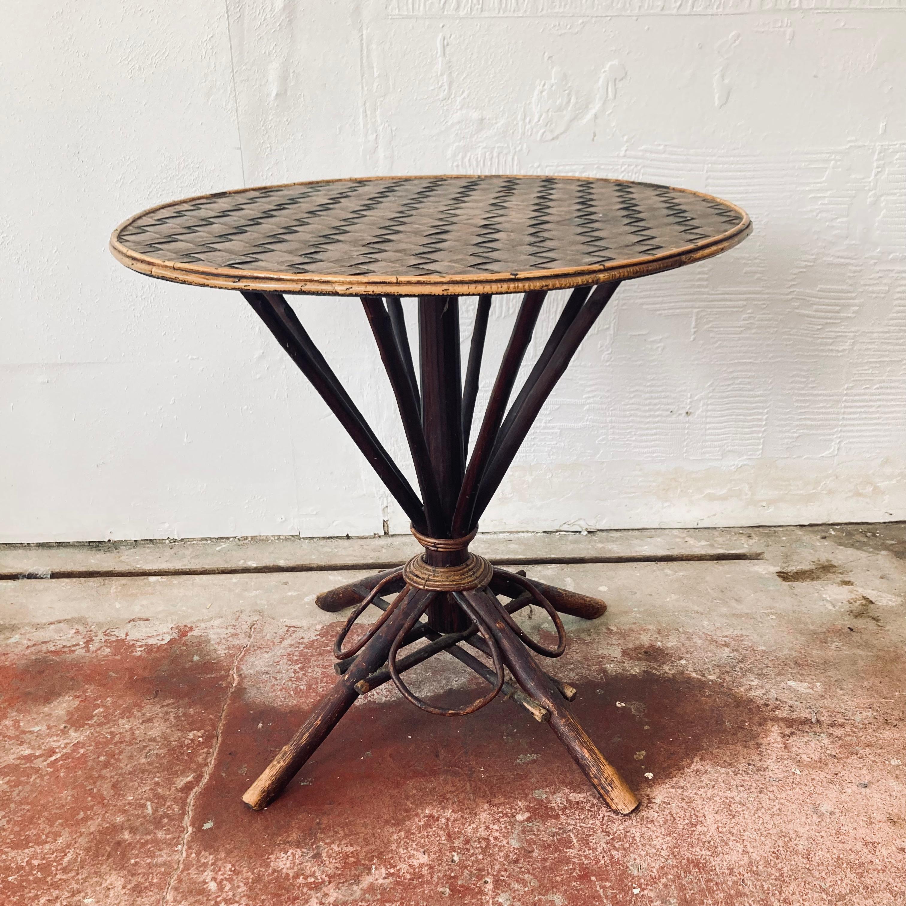 A unique, rustic , Folk Art piece. This circular table is perfect for a hallway, or any space that requires a centre table. It features bent and twisted twigs, bamboo leg, woven top and trimmed with further split wood. 

It is a great fun piece,