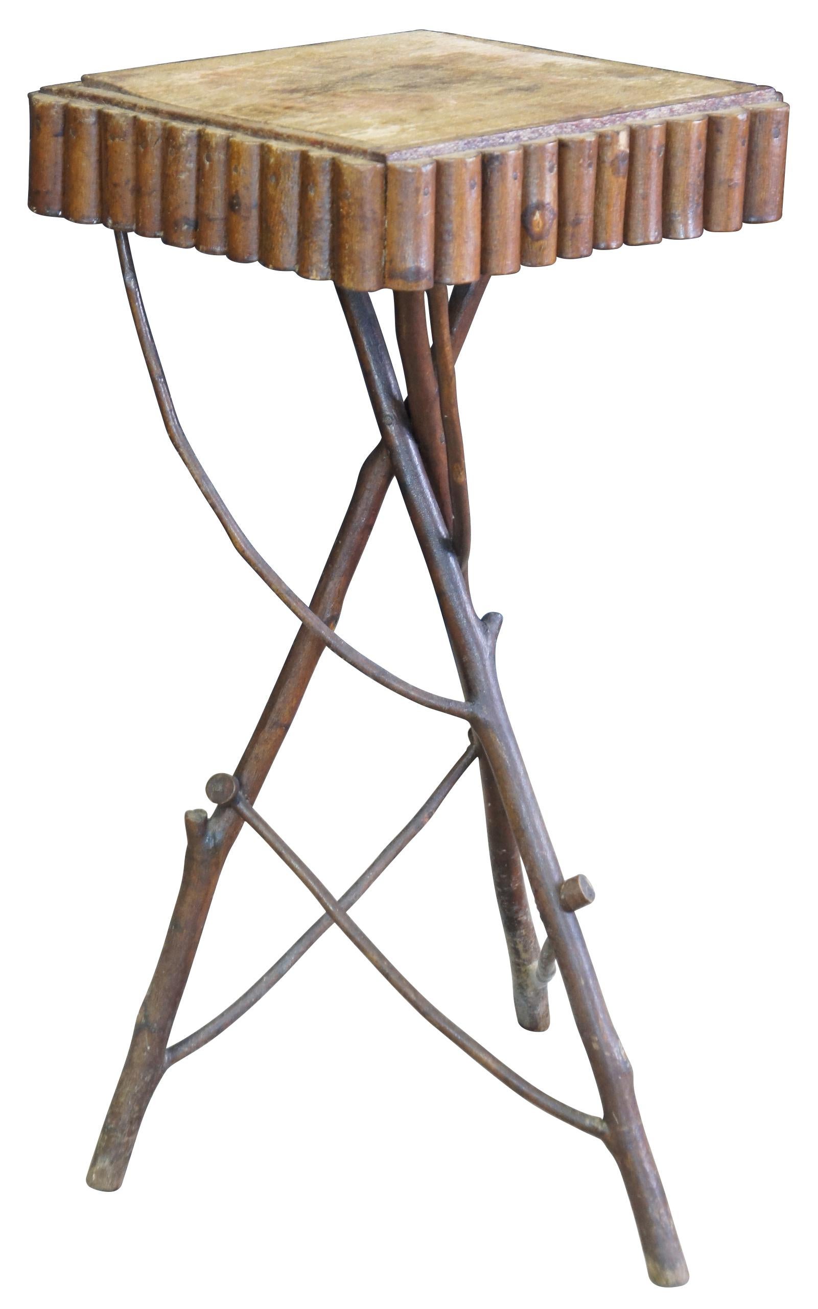 A lovely adirondack table with a branched tripod base leading to a square top trimmed in quarter cut branches. Measure: 26