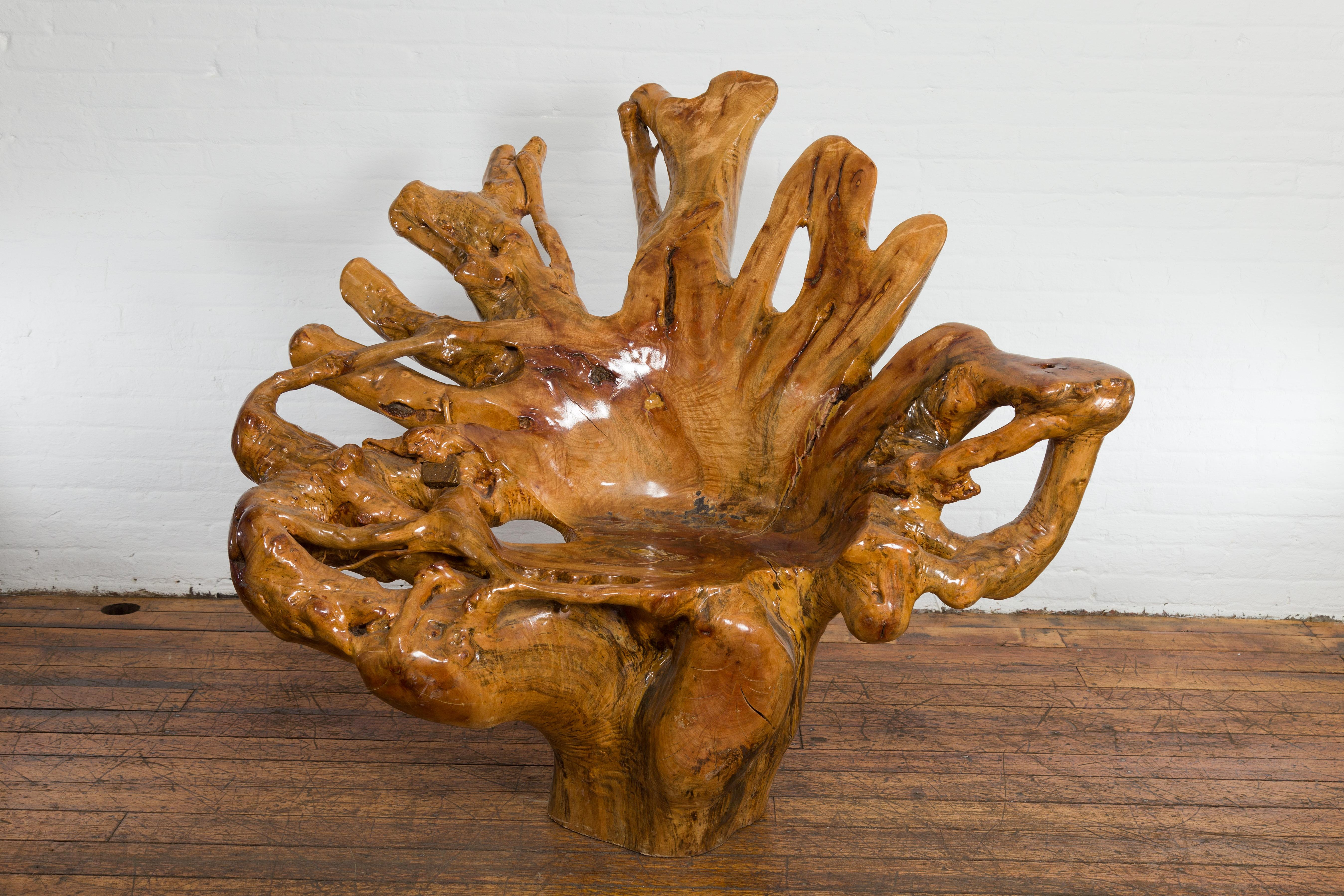 Questa sedia scultorea con radici in legno di canfora è un esempio straordinario di arte e artigianato naturale. Scolpita a mano da una singola radice d'albero, la forma segue le linee organiche del legno stesso, creando una silhouette profondamente