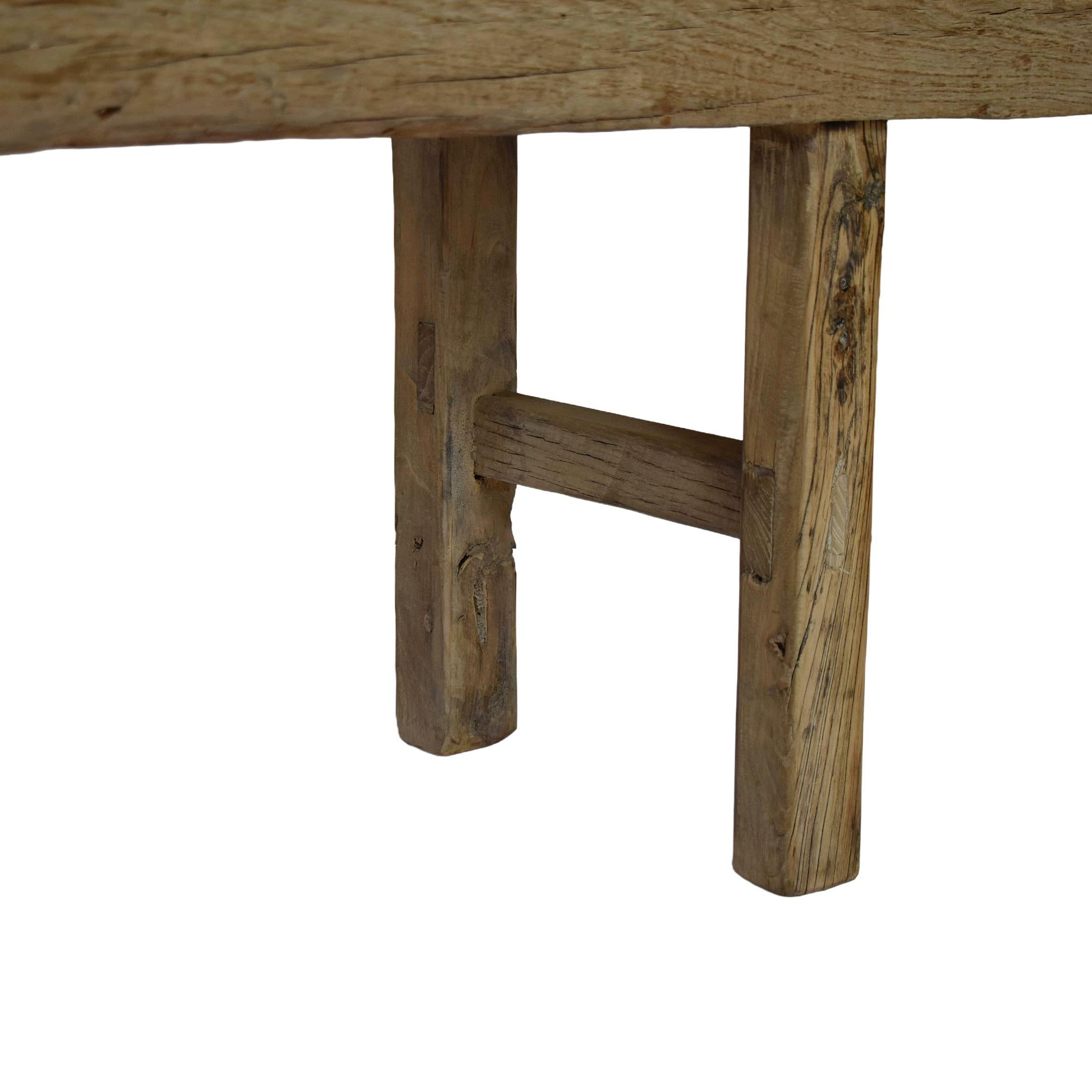 Realizzata a mano in legno di olmo, questa panca ha una storia di versatilità. La patina naturale e le riparazioni invecchiate creano un pezzo unico e irripetibile. Molto dettagliato, con una costruzione primitiva a mortasa e tenone e gambe a croce.