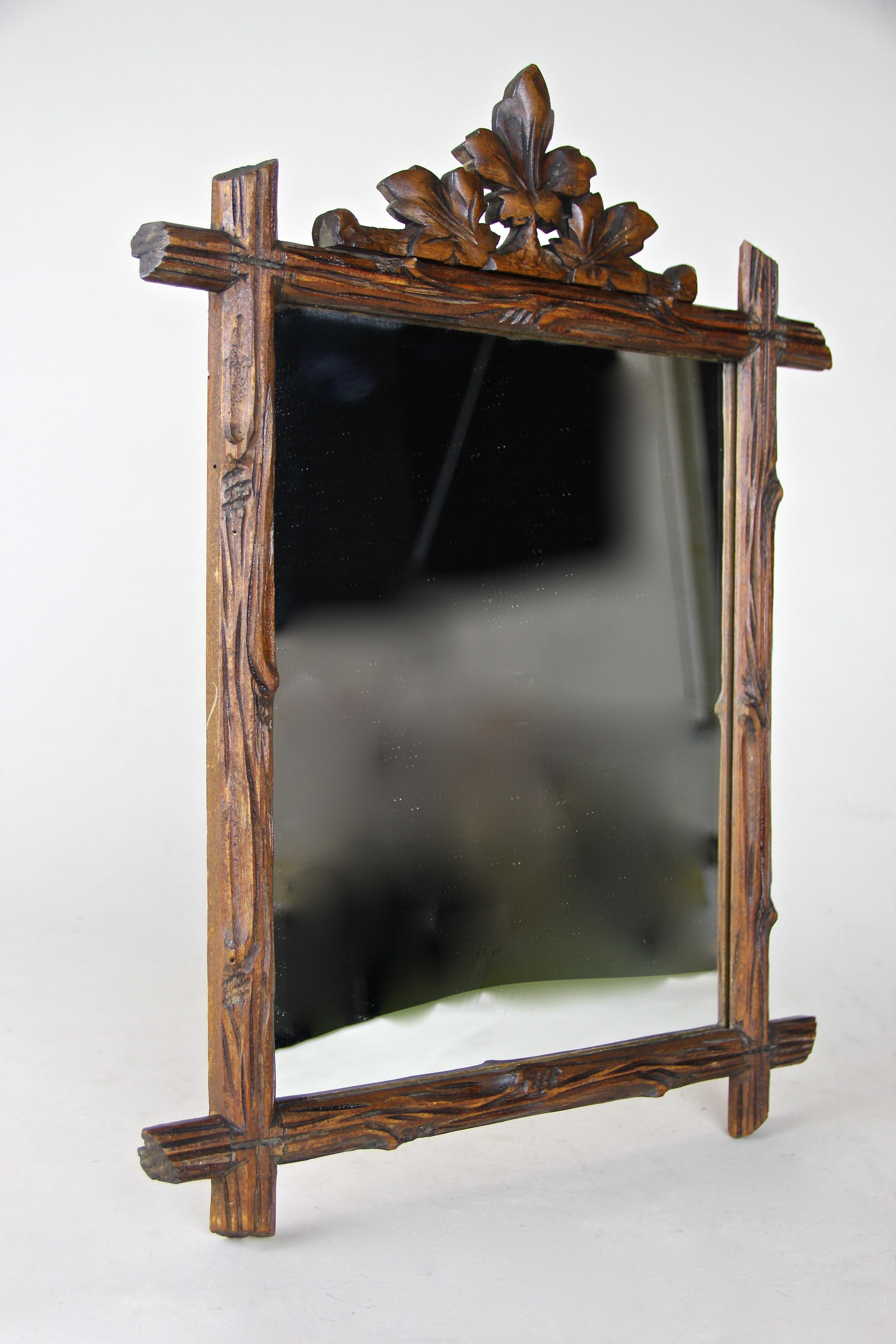 Small rustic wall mirror from Austria circa 1890, artfully hand carved out of softwood. Stained and waxed, the frame impresses with its 