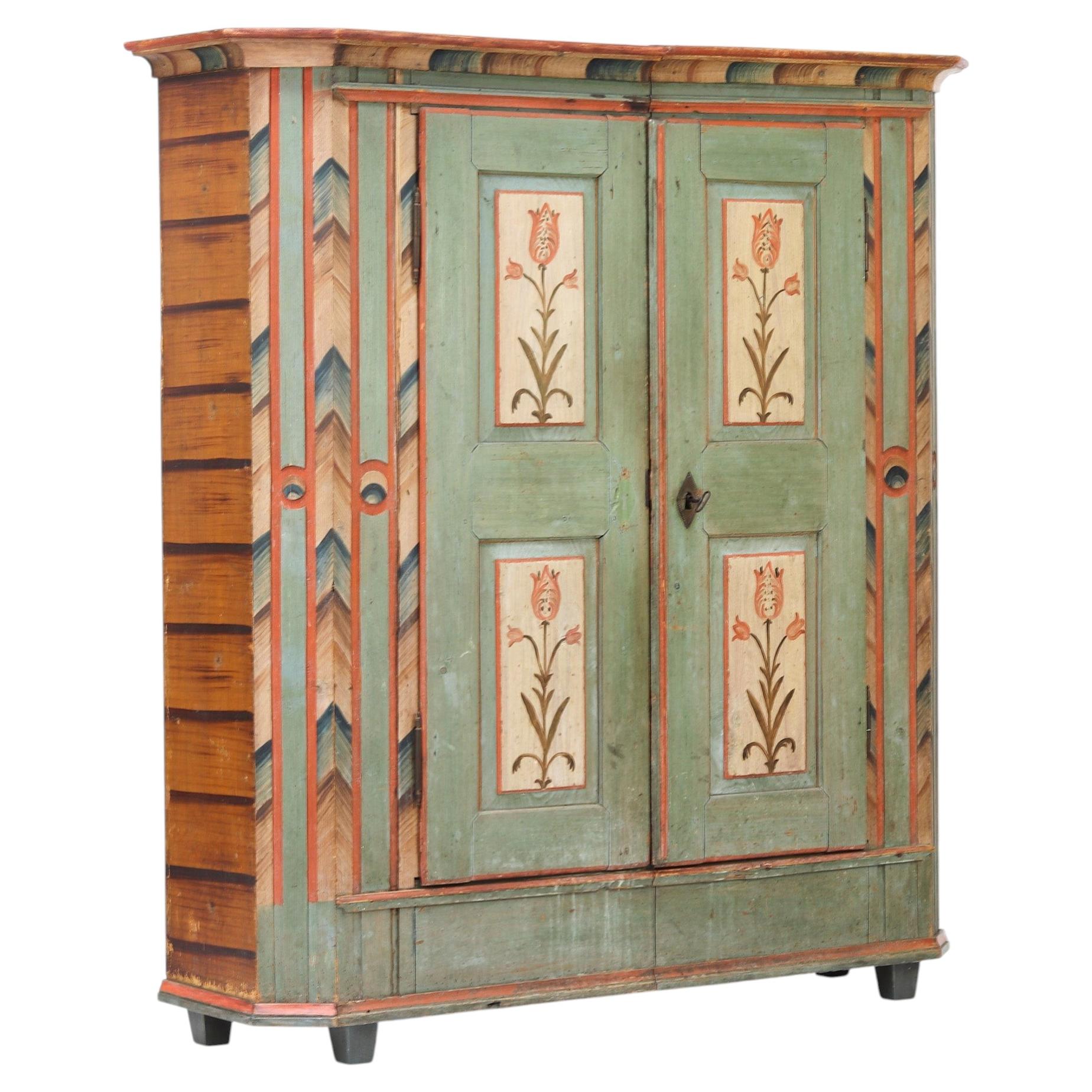 Armoire de mariée peinte dans un style rustique et patiné, inspirée de l'art populaire des fermes