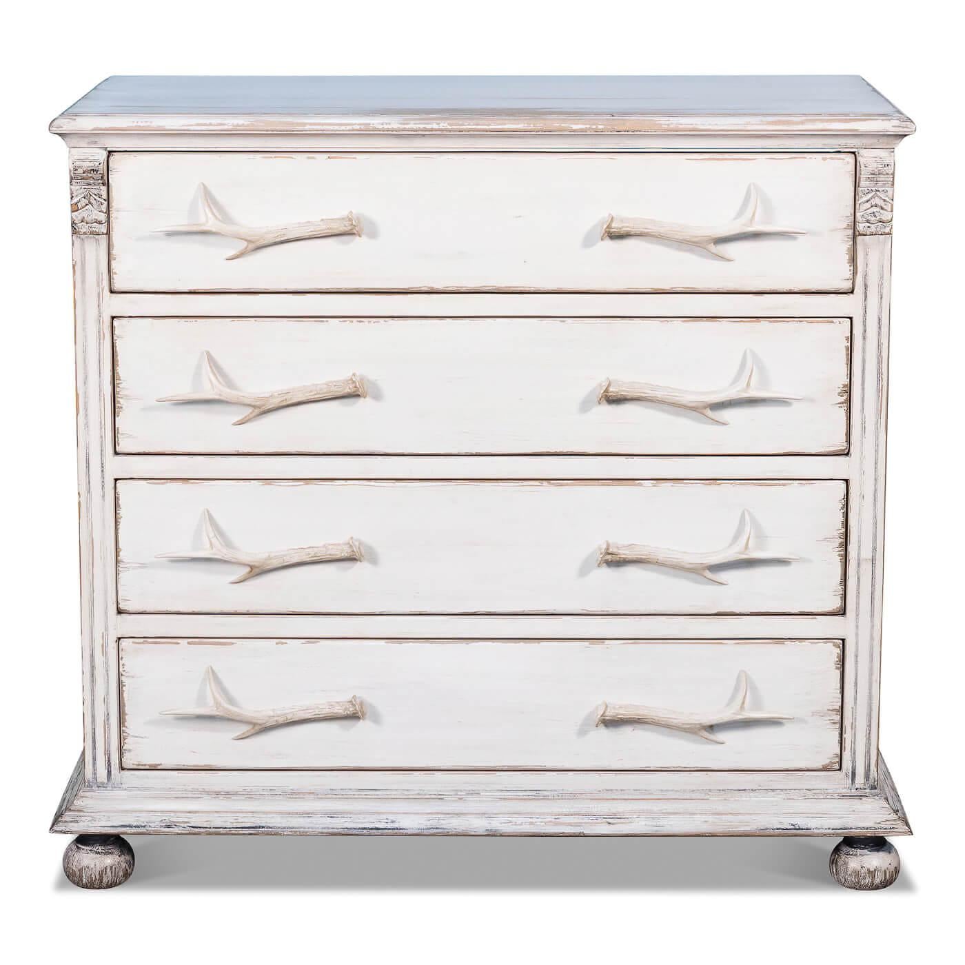 A rustic whitewashed dresser with antler handles. This four-drawer chest is made of reclaimed pine and has been given a hand0rubbed and antiqued painted whitewash finish. 

Dimensions: 44