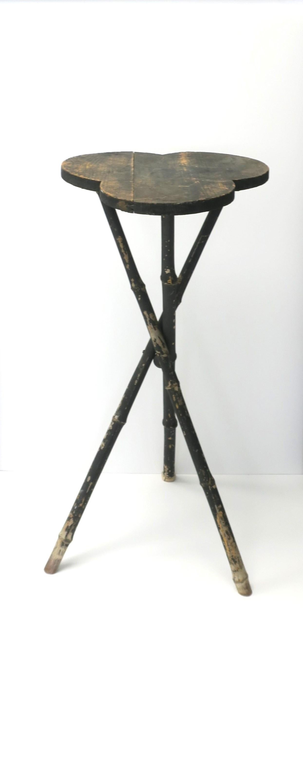 Table d'appoint, d'appoint ou pour plantes, en bois rustique et bambou, avec un plateau de type Trefle français et une base en bambou à trois pieds, vers la fin du 20e siècle. Le plateau de la table est en bois et présente un motif de trèfle