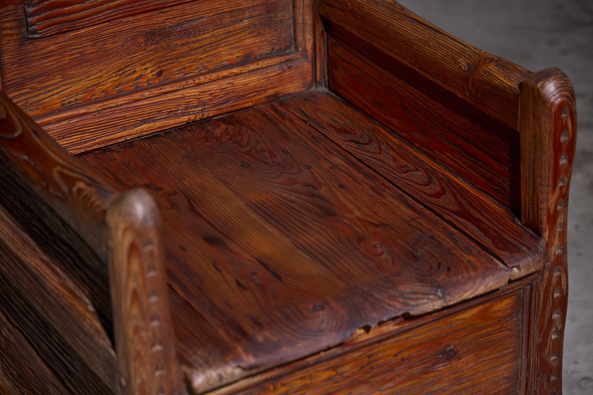 Poltrona francese in legno rustico del XIX secolo con una base unica a forma di organo, braccioli dritti e una seduta sollevabile che rivela un vano portaoggetti nascosto. Il pezzo è caratterizzato da una notevole patina che incarna magnificamente