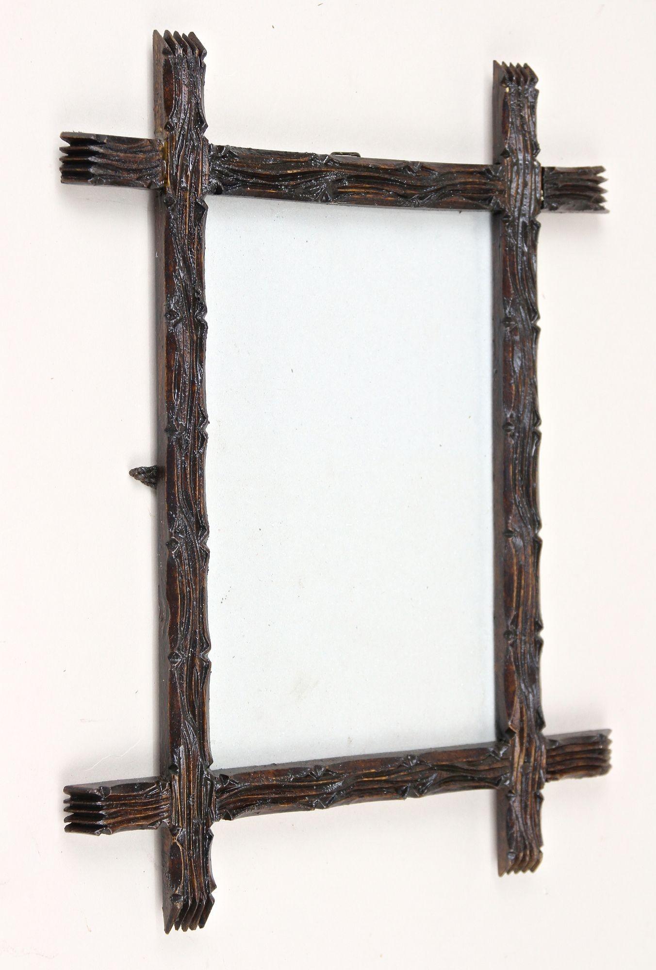 Elaborately handcarved rustic Black Forest photo frame from the 19th century around 1860 in Austria. Crafted out of bass wood this antique photo frame shows a charming traditional tree bark design which the dark brown almost black stained surfaces