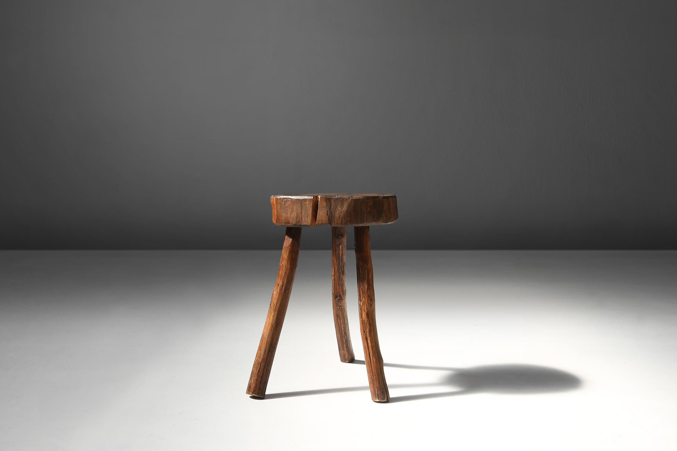 Dieser aus einem Baumstamm gefertigte Holzhocker aus dem 19. Jahrhundert ist ein einzigartiges und authentisches Möbelstück, das jedem Raum eine rustikale Atmosphäre verleiht.

Der Hocker hat drei robuste Beine, die der natürlichen Form des Baumes