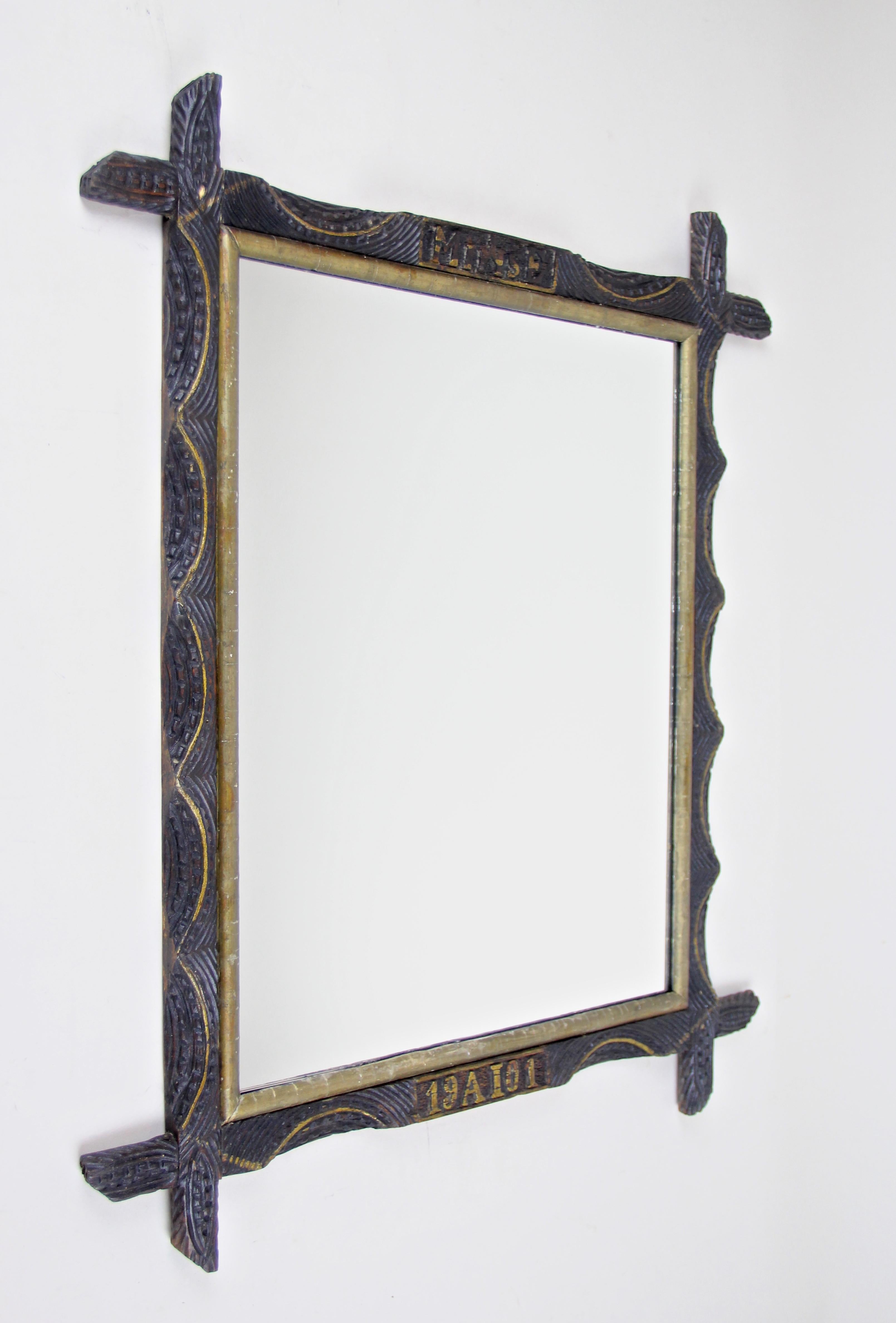 Peerless rustic wooden wall mirror from Austria, dated to 1901. A very special designed wall mirror with a golden bar on the inside and protruding corners. Artfully hand carved, this unique frame impresses with its beautiful shaped wave forms and