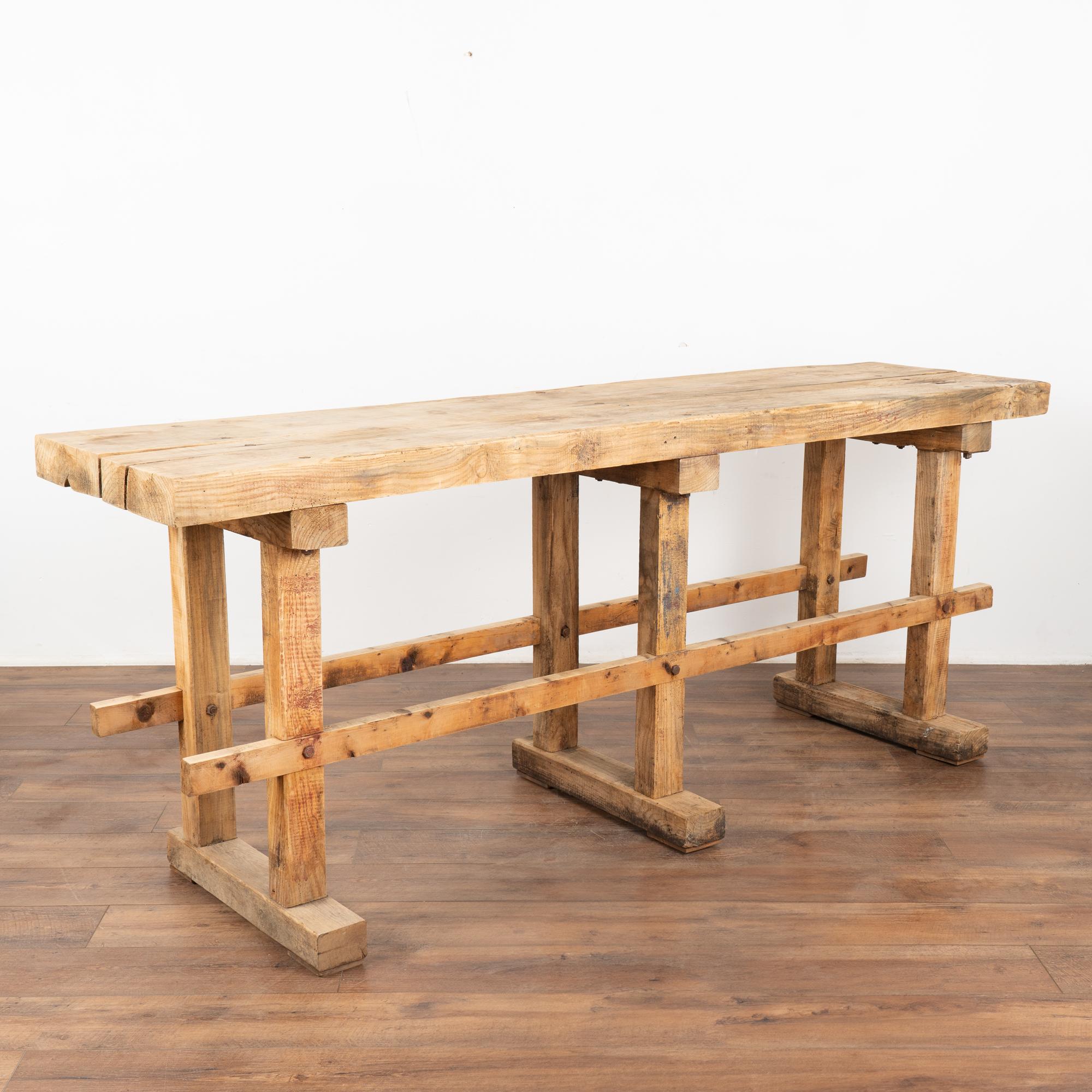 The strong appeal of this rustic console table comes from the well worn top reflecting generations of use.
It originally served as a work table, resulting in the worn patina with deep gouges, cracks, scrapes, stains, and old gnarls.
This console