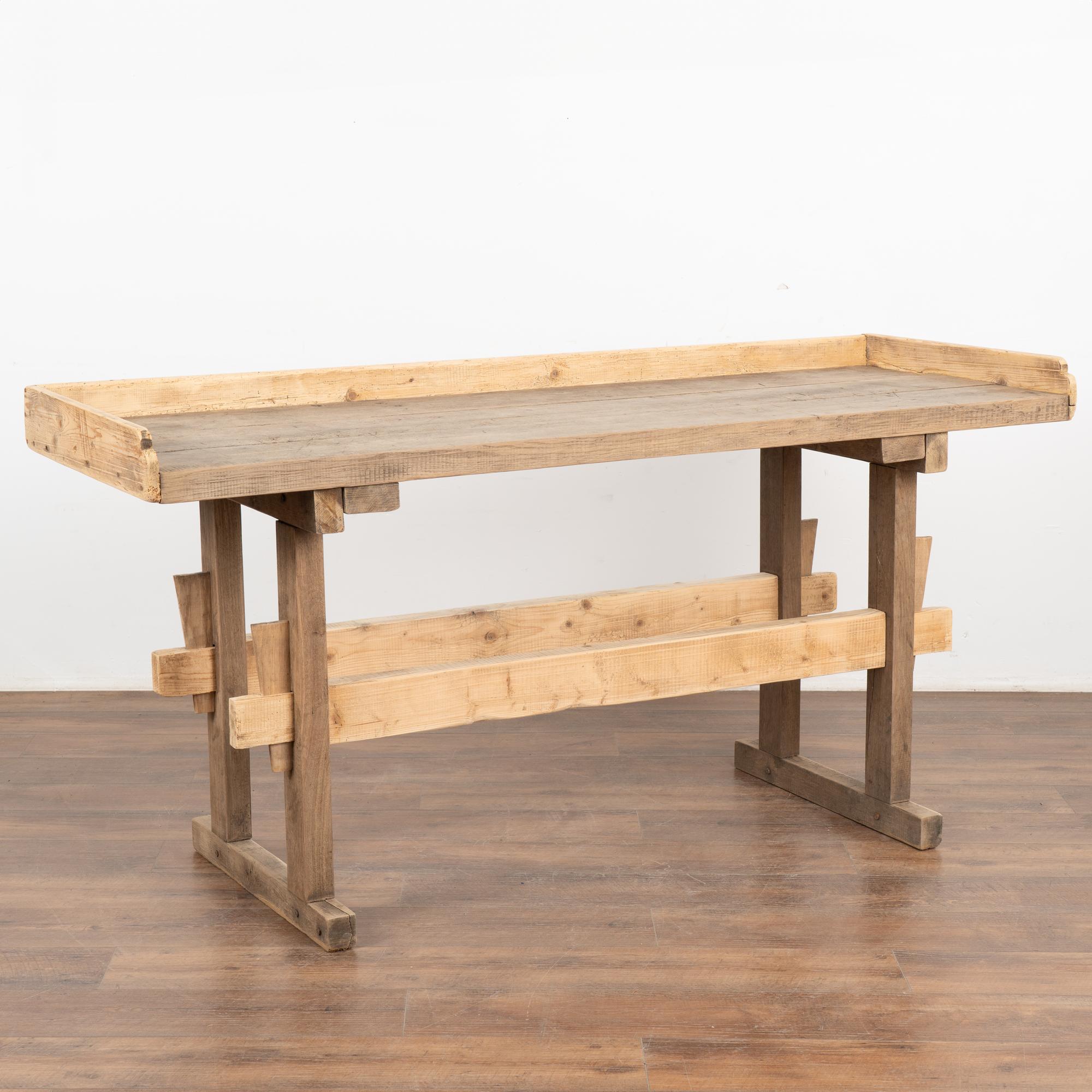The strong appeal of this rustic console table comes from the well worn top reflecting generations of use.
It originally served as a work table, resulting in the worn patina with deep gouges, cracks, scrapes, stains, and old gnarls.
A back and side
