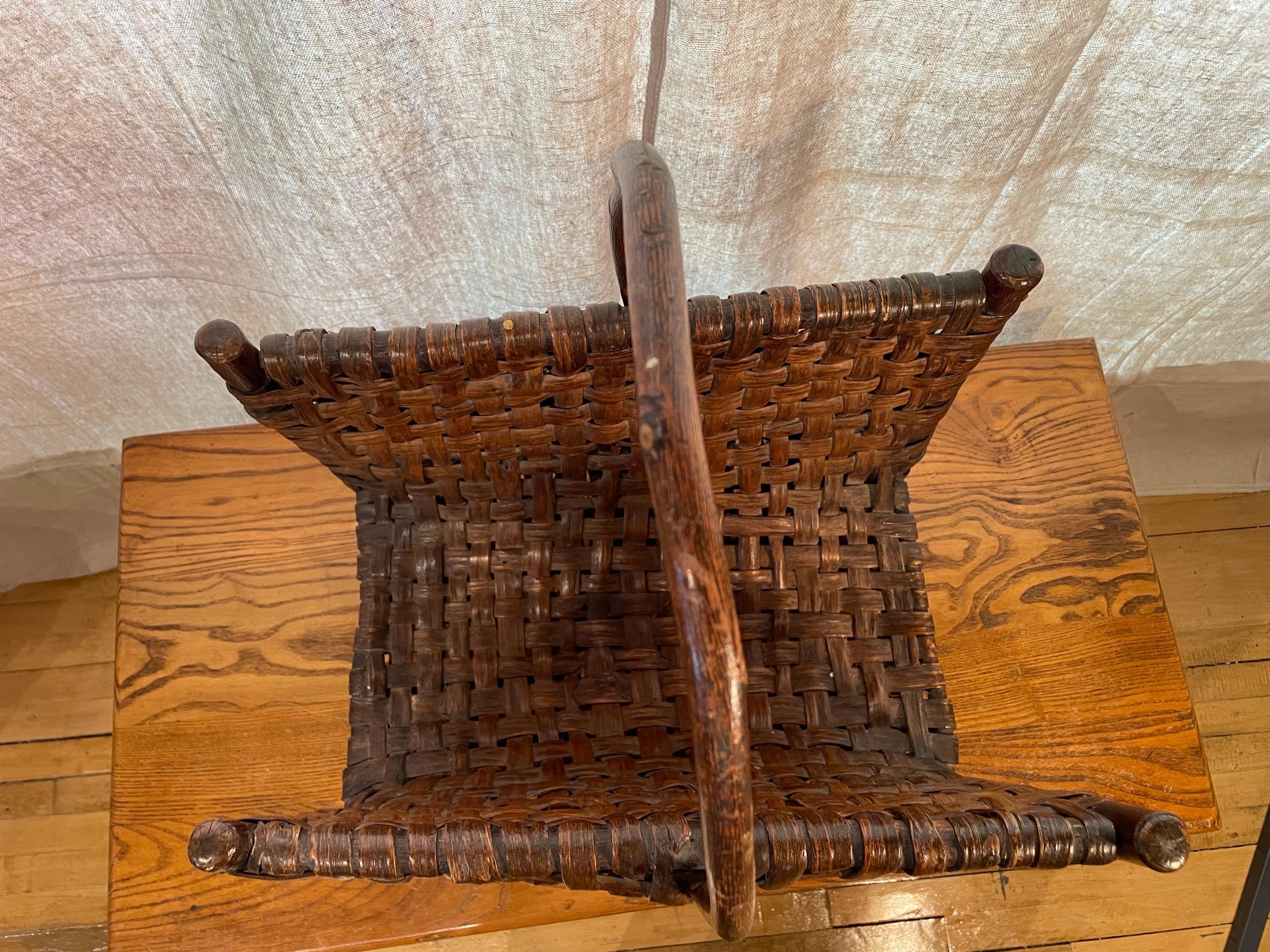 This handwoven hickory basket, attributed to the renowned Old Hickory Furniture Company of Indiana, exemplifies the rustic elegance and enduring craftsmanship that defined early 20th-century American design. Crafted from hickory saplings and