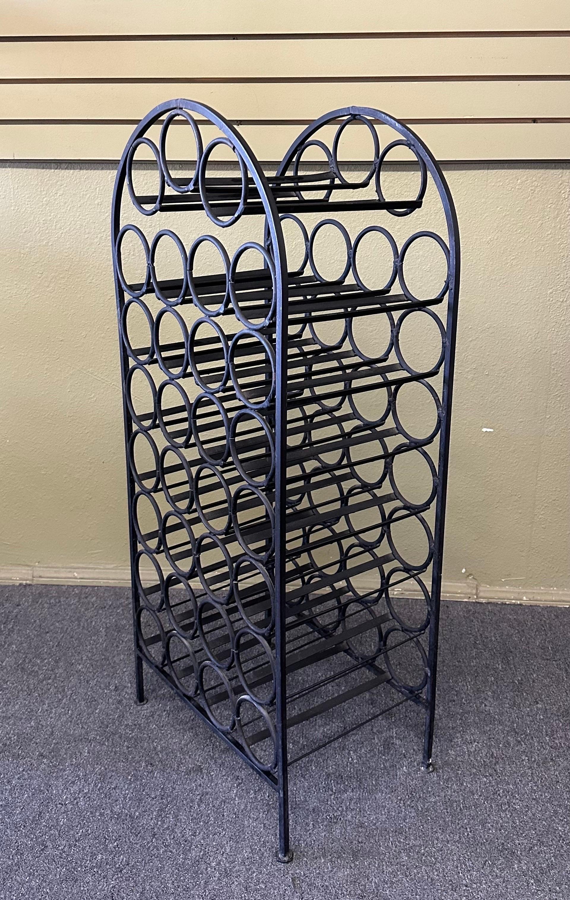 A very nice rustic wrought iron wine rack / cabinet, circa 1970s. The piece is in rustic worn condition and holds 31 bottles of wine. The cabinet has a wonderful patina and measures 18