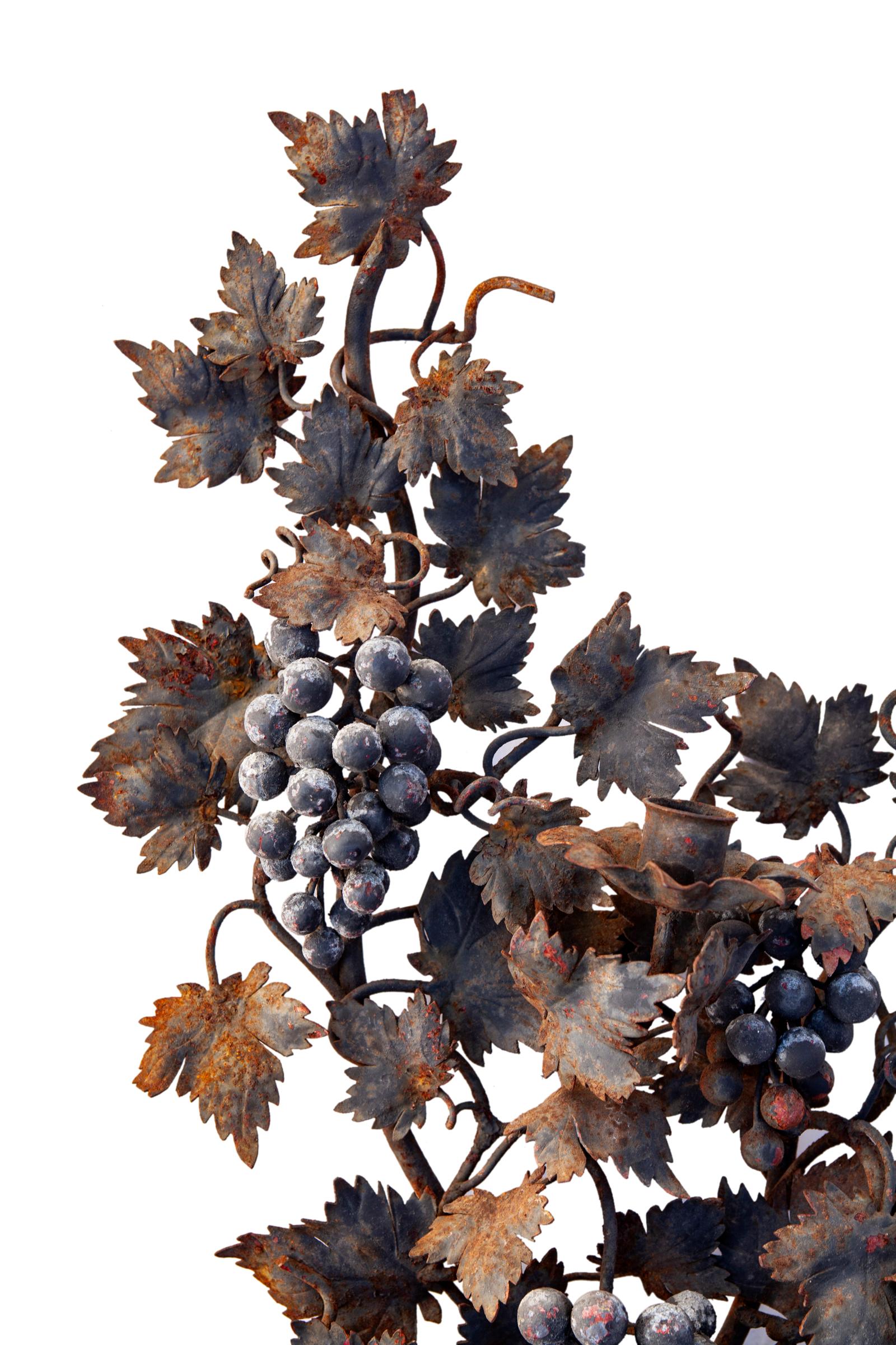 Charming rustic iron sconce, hand crafted in Italy.
Clusters of grapes are surrounded by lacy grape leaves. 
The iron grapevines are very detailed. 
As found, lovely aged patina.