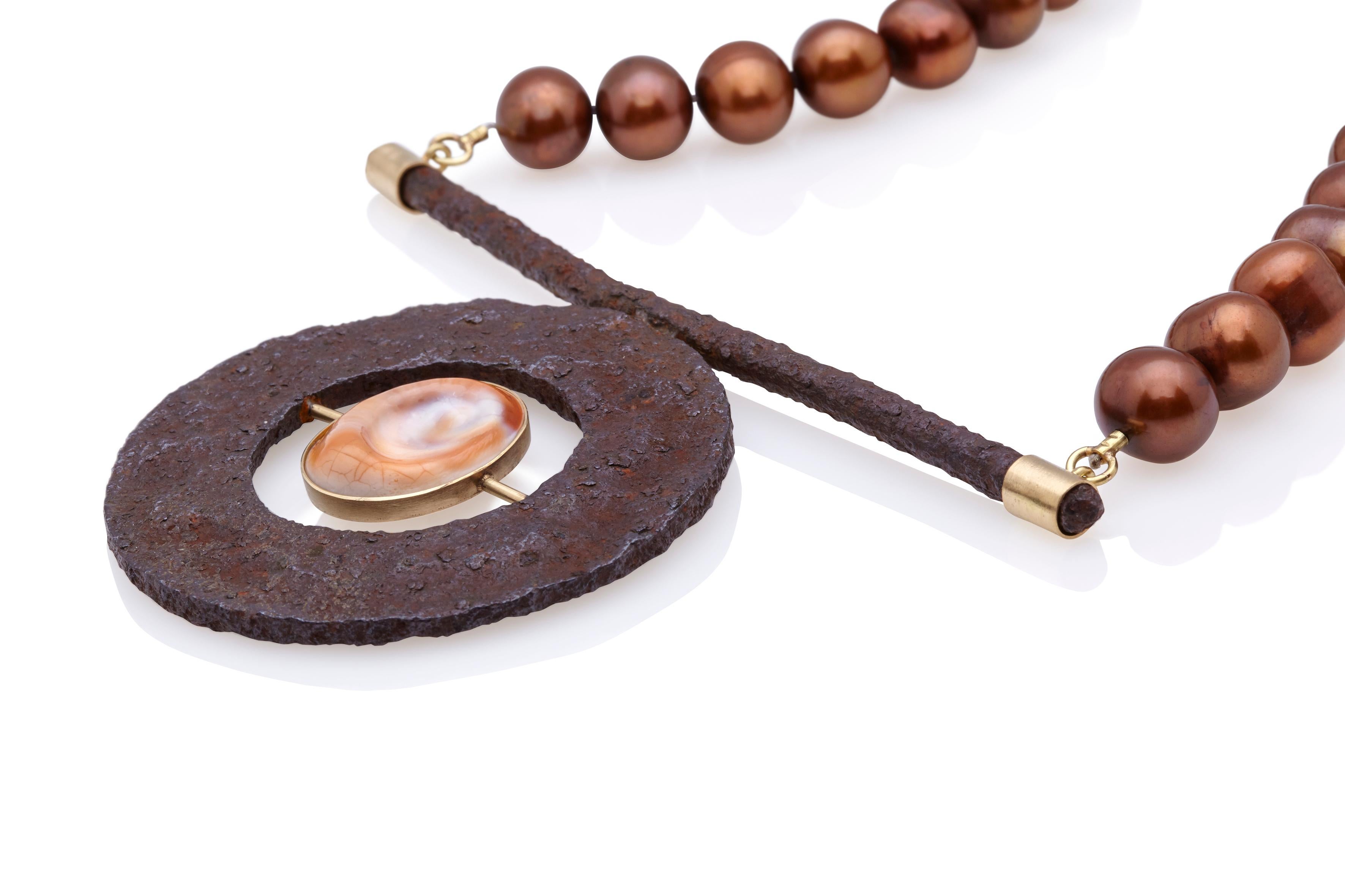 An exceptional and unique necklace made of round founded rusty object, chocolate pearl, operculla (cat's eye shell) and 18Kt yellow gold. A unique piece that will catch everyone's eye and will add a serious statement to your outfit. Handcrafted