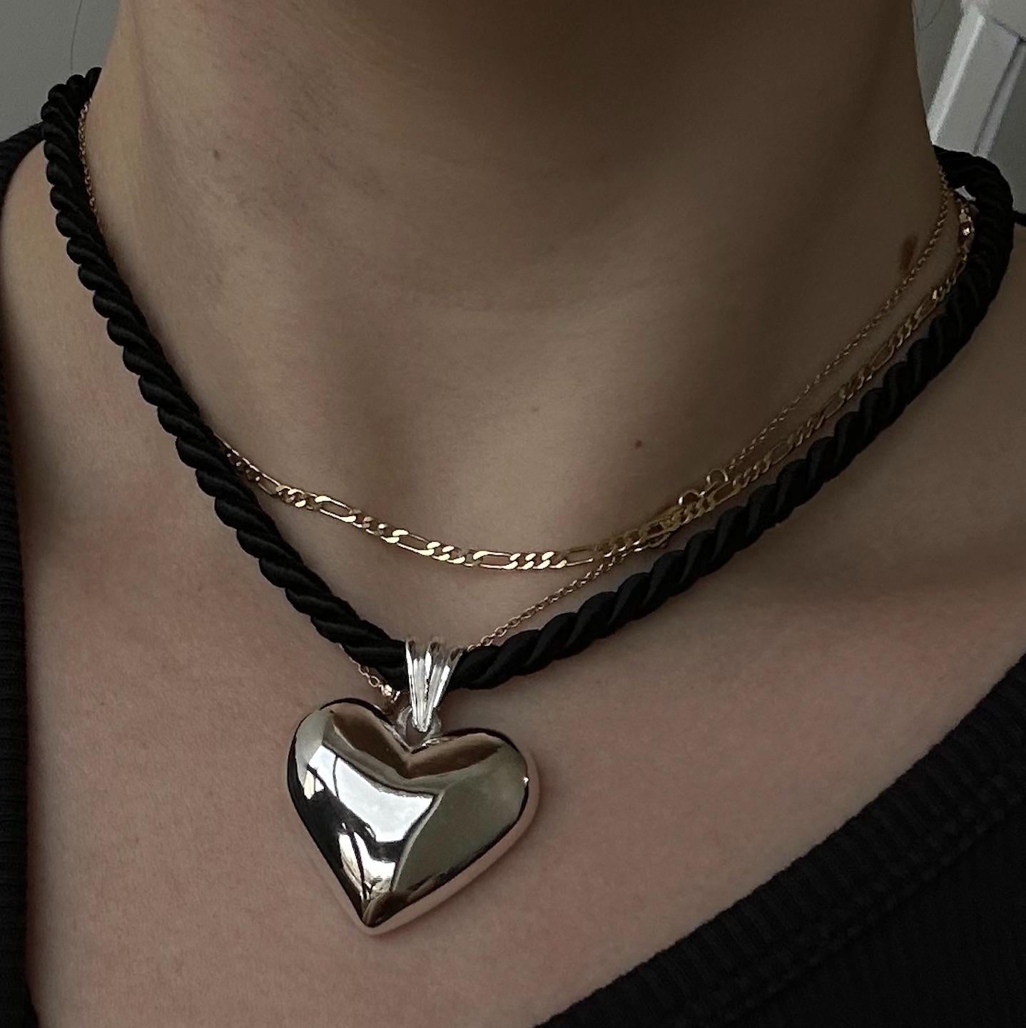 The Heavy Heart Pendant is crafted from 14k yellow gold and hung on a twisted cotton cord. A piece that feels trend-forward, but is made to last forever. 

Lays flat on the neck
Adjustable between 16-18' inches
Lobster clasp closure 

Each Ruth Nyc