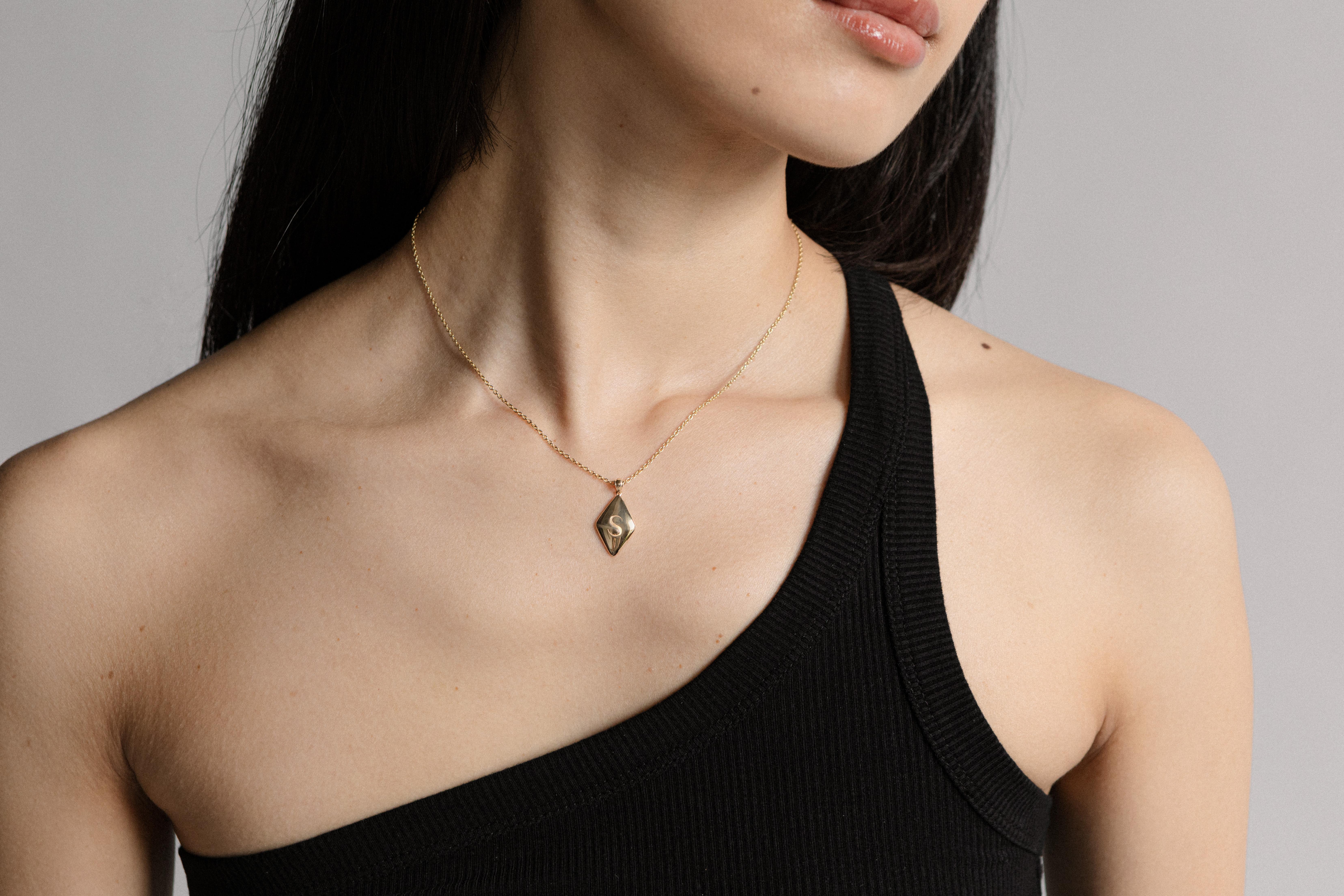 The line between exaggeration and expression is drawn by subtlety.  
Designed to represent a piece of sentimentality in your daily life, the Kite Pendant has a unique yet simple shape with a custom font to match. Enjoy the design on its own, or