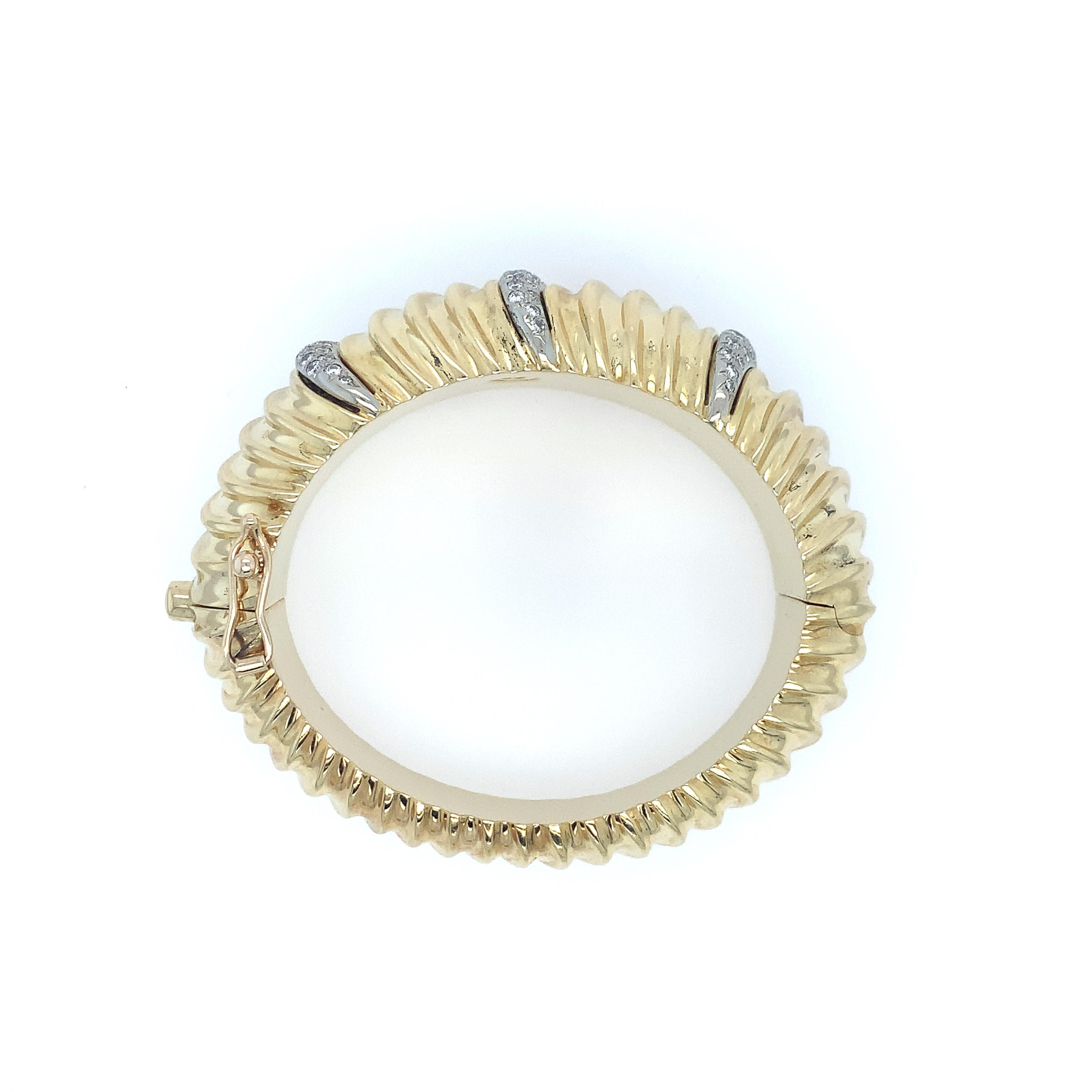 A fabulous piece by the artist and jeweler Ruth Satsky. Manufactured in the late twentieth century, this piece is simply one of a kind. Made of polished solid gold, this oval shaped bangle bracelet is designed with a scalloped pattern tapering down