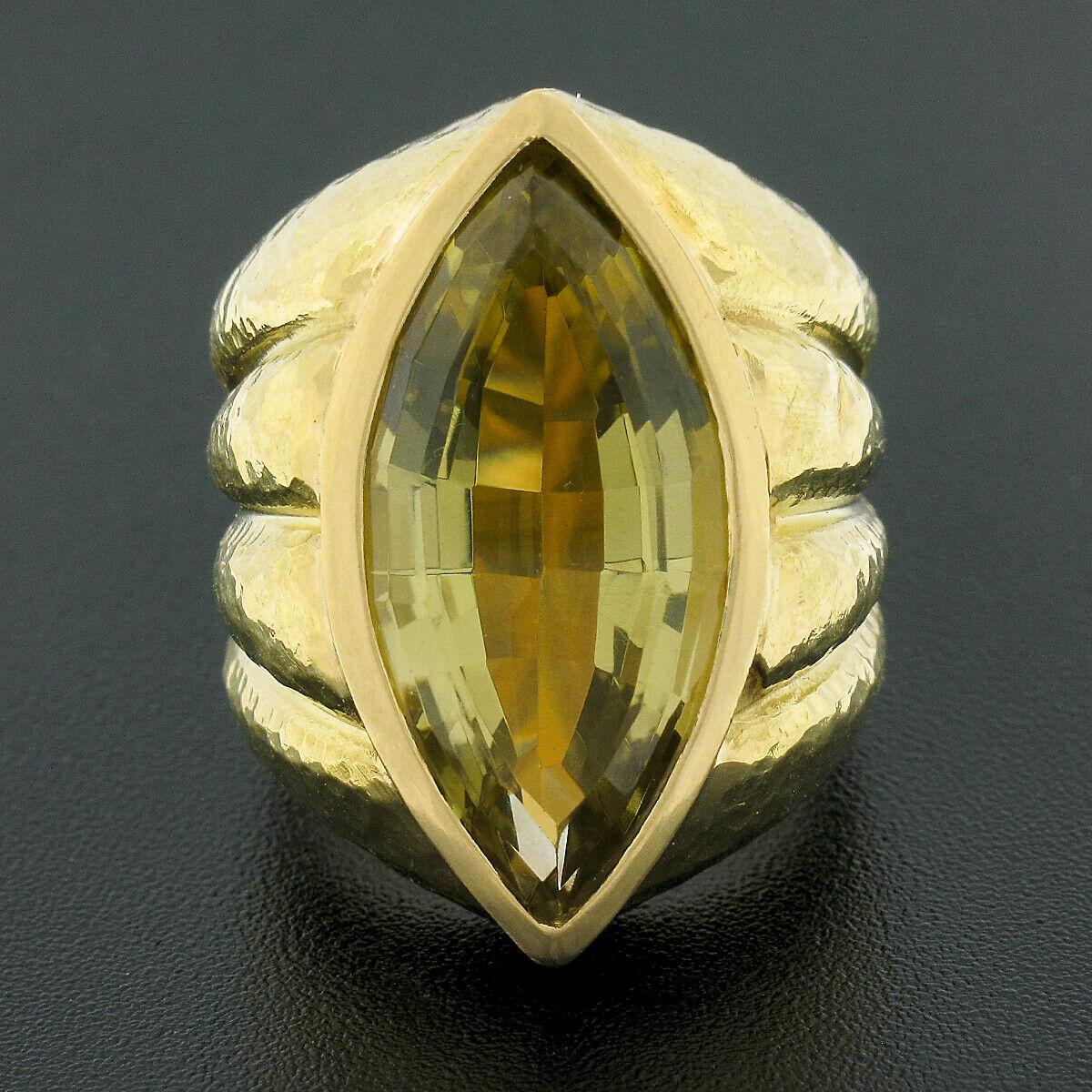 This magnificent cocktail band ring is crafted in 18k yellow gold and was designed by Ruth Satsky featuring a magnificent, marquise cut, lemon quartz neatly bezel set at the center of a polished finish frame. The large and stunning solitaire