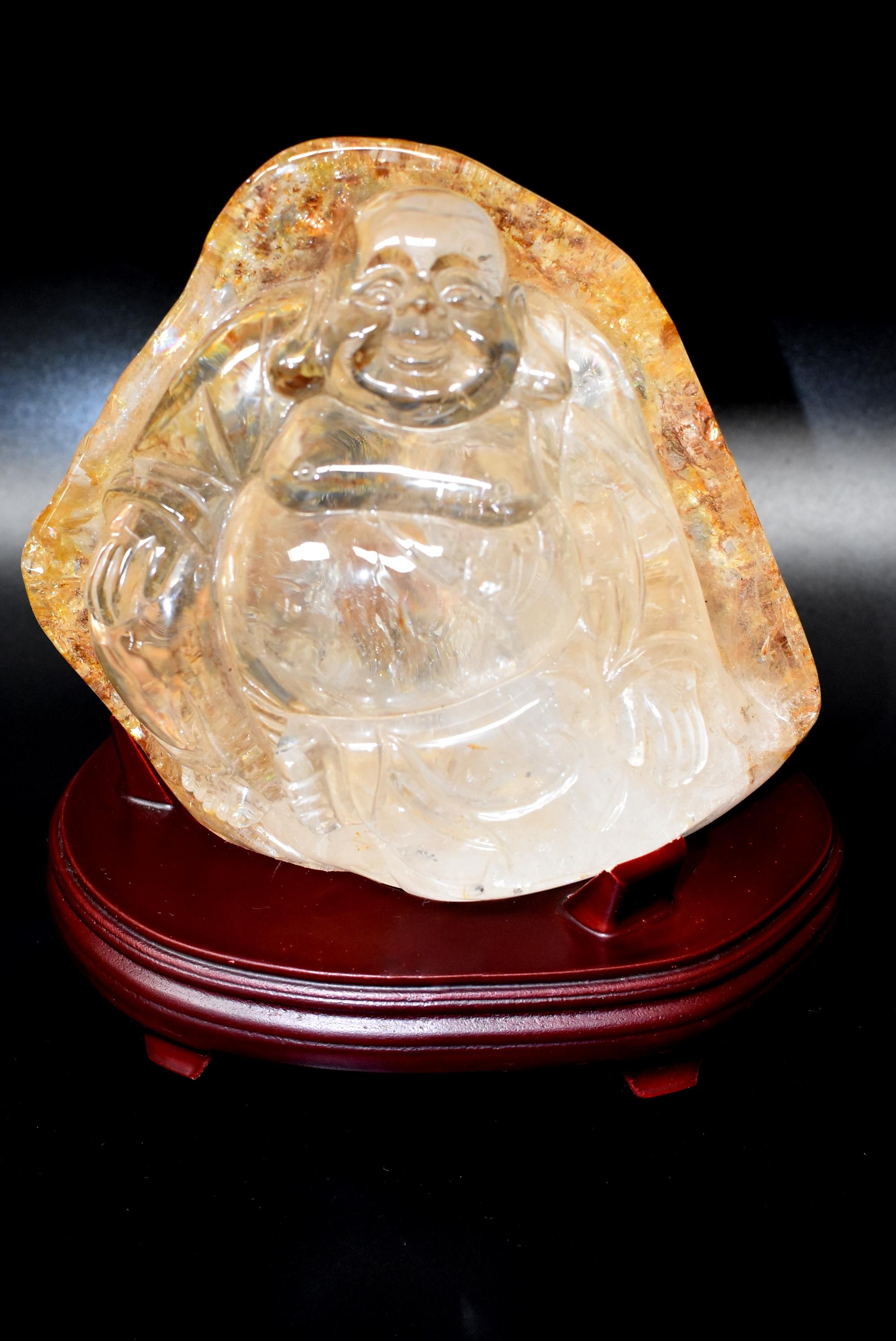 A stunning, extra large, all natural crystal sculpture of a Chinese Happy Buddha. The boulder is crystal clear with beautiful gold threads and moss covering the back. It weighs an incredible 7 lb total. This is an absolutely beautiful piece that is
