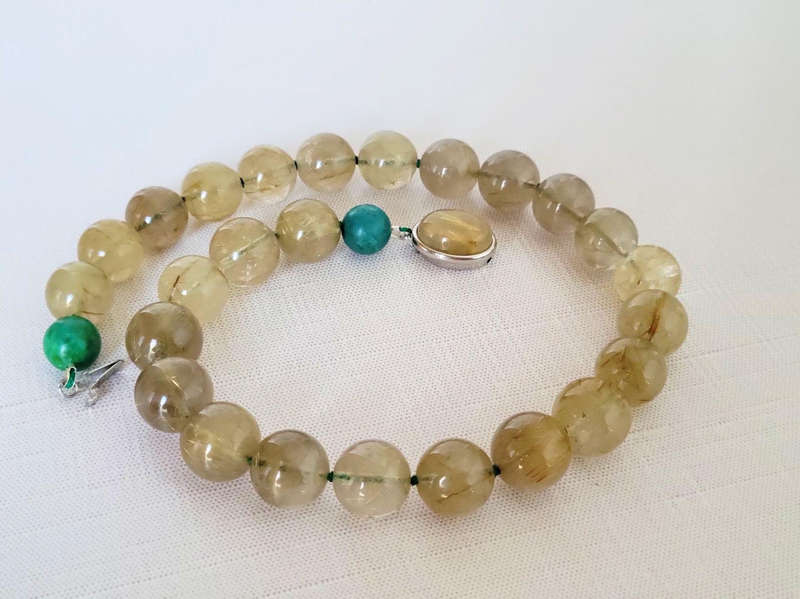 Siamo lieti di presentare una splendida aggiunta alla nostra collezione: una collana annodata di quarzo rutilato con due perle di turchese. Con una lunghezza di 45,7 cm, questo pezzo squisito è realizzato con perle di quarzo rutilato rotonde e lisce
