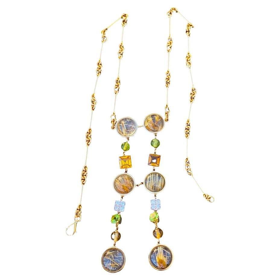 Rutilated Quartz and Diamond Peridot Necklace 18 Karat Yellow Gold
Gorgeous dangle necklace with double dangling gemstones. The round and square bezels give a geometric architectural flair to the design of this necklace.
Measurements are 16
