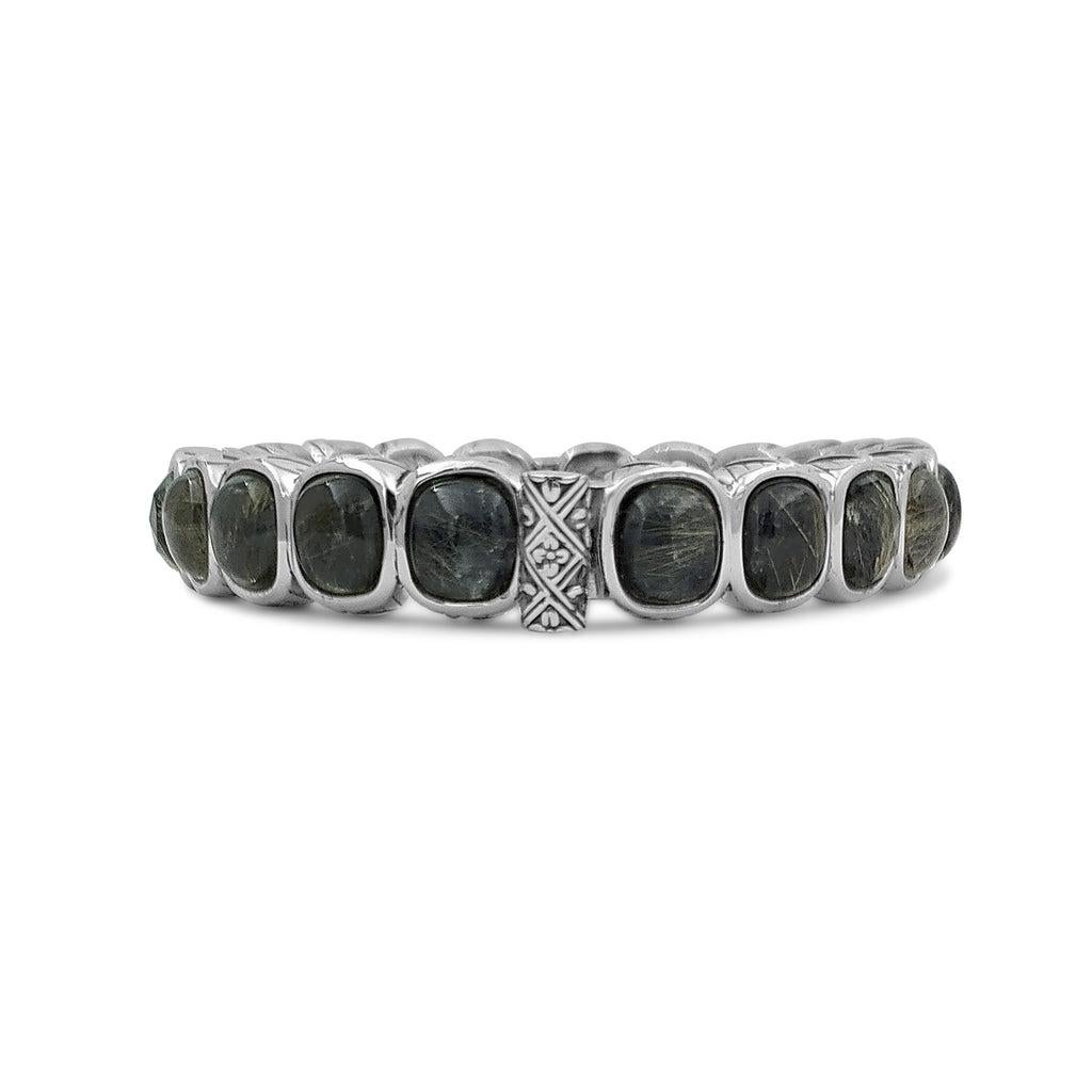 Step into a world of sophistication and elegance with this stunning Rutilated Quartz and Hematite Bangle, expertly crafted in sterling silver. The intricate combination of rutilated quartz and hematite creates a mesmerizing visual effect, with each