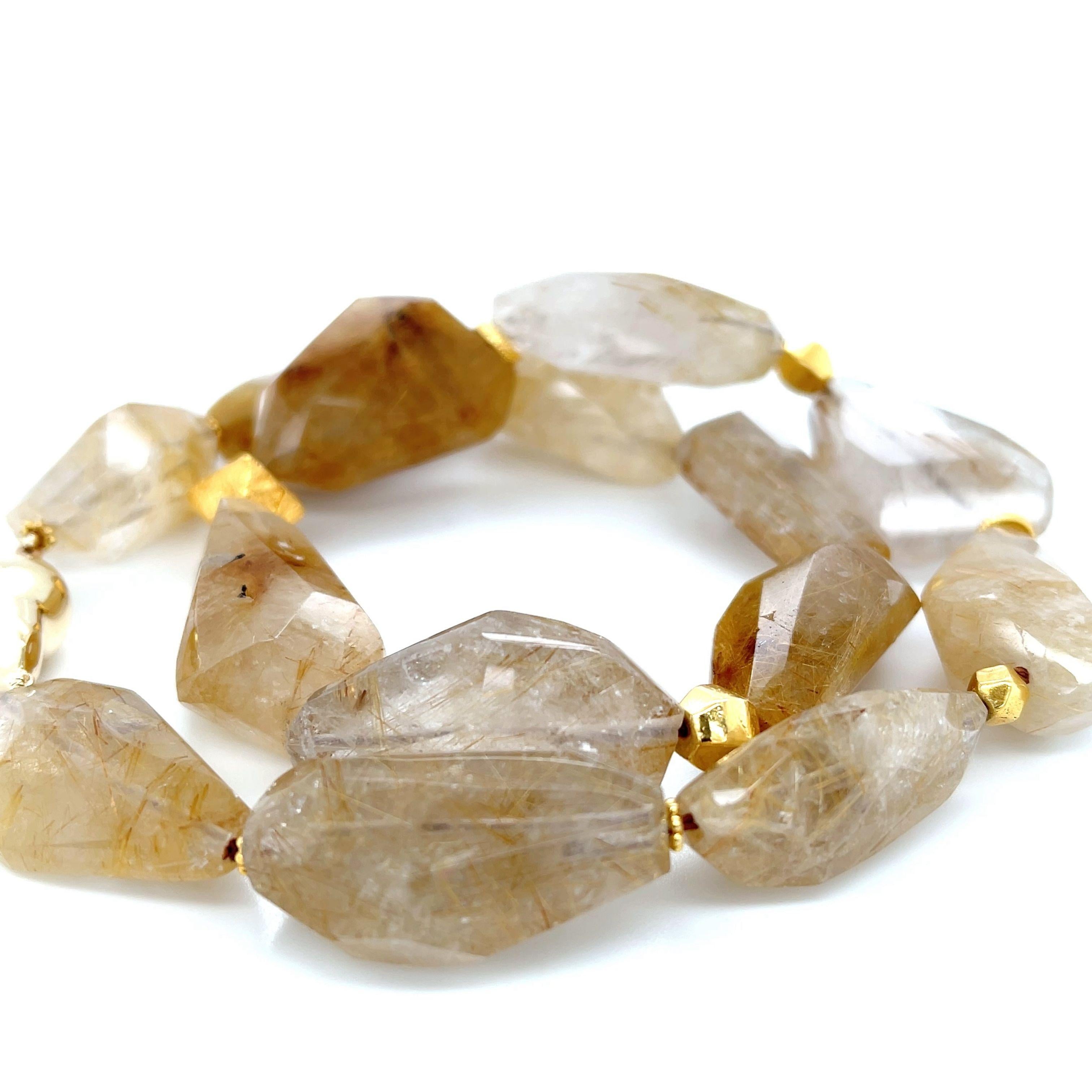 Ce collier de pierres précieuses et d'or est composé d'une impressionnante collection de cristaux de quartz rutile facettés en perles de forme libre. Les pépites de quartz semi-transparentes sont de grande taille, mesurant en moyenne 12,00 x 18,00