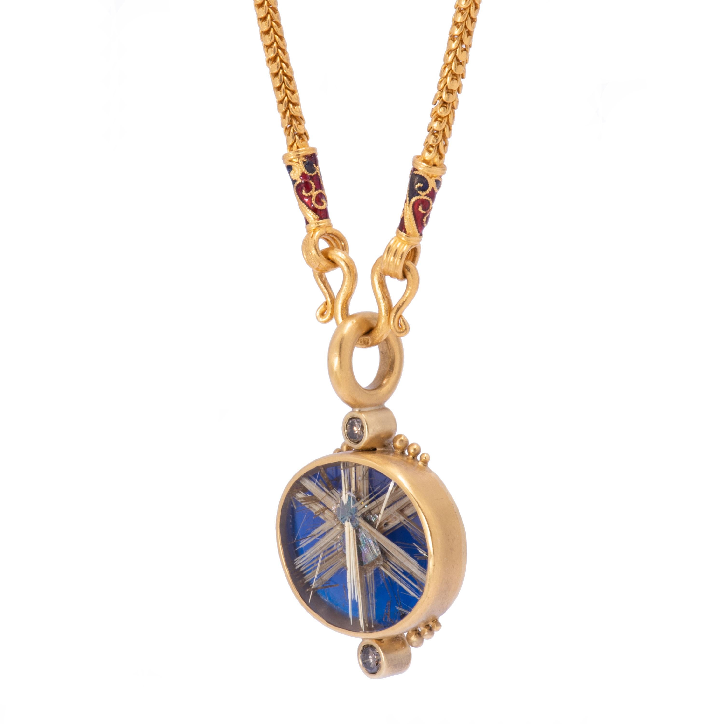 A multi-dimensional Rutilated Quartz in a starburst pattern is backed with deep blue resin and accented with glimmering cognac diamonds .53 tcw. A row of graduated gold beads frame each diamond above and below. The interior of the quartz is streaked