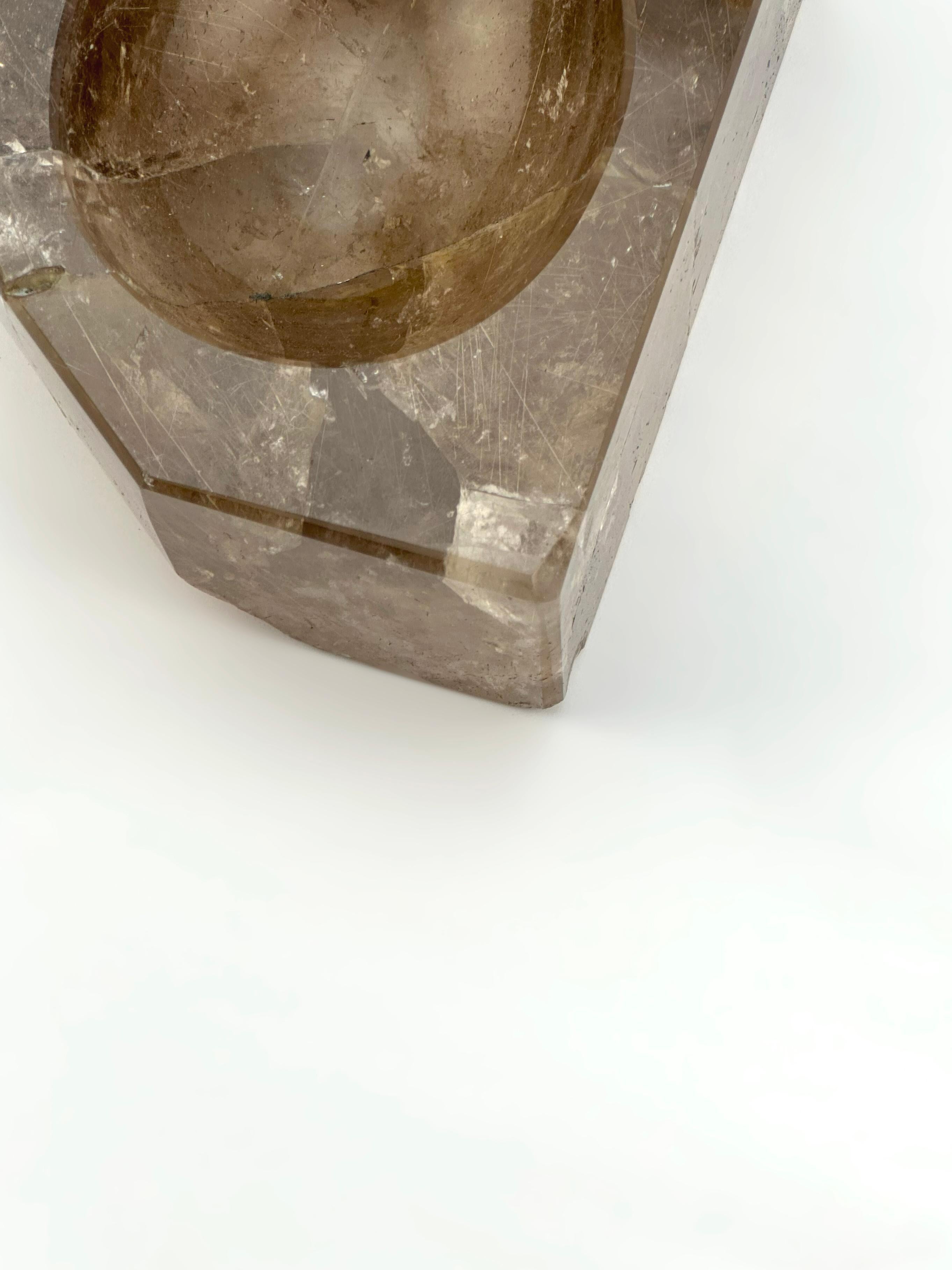 An exceptional example of natural crystal carving, this substantial smoky quartz bowl is crafted from a rare variety of quartz rich in golden rutile inclusions. The yellow rutile needles are suspended within the semi-translucent quartz matrix,