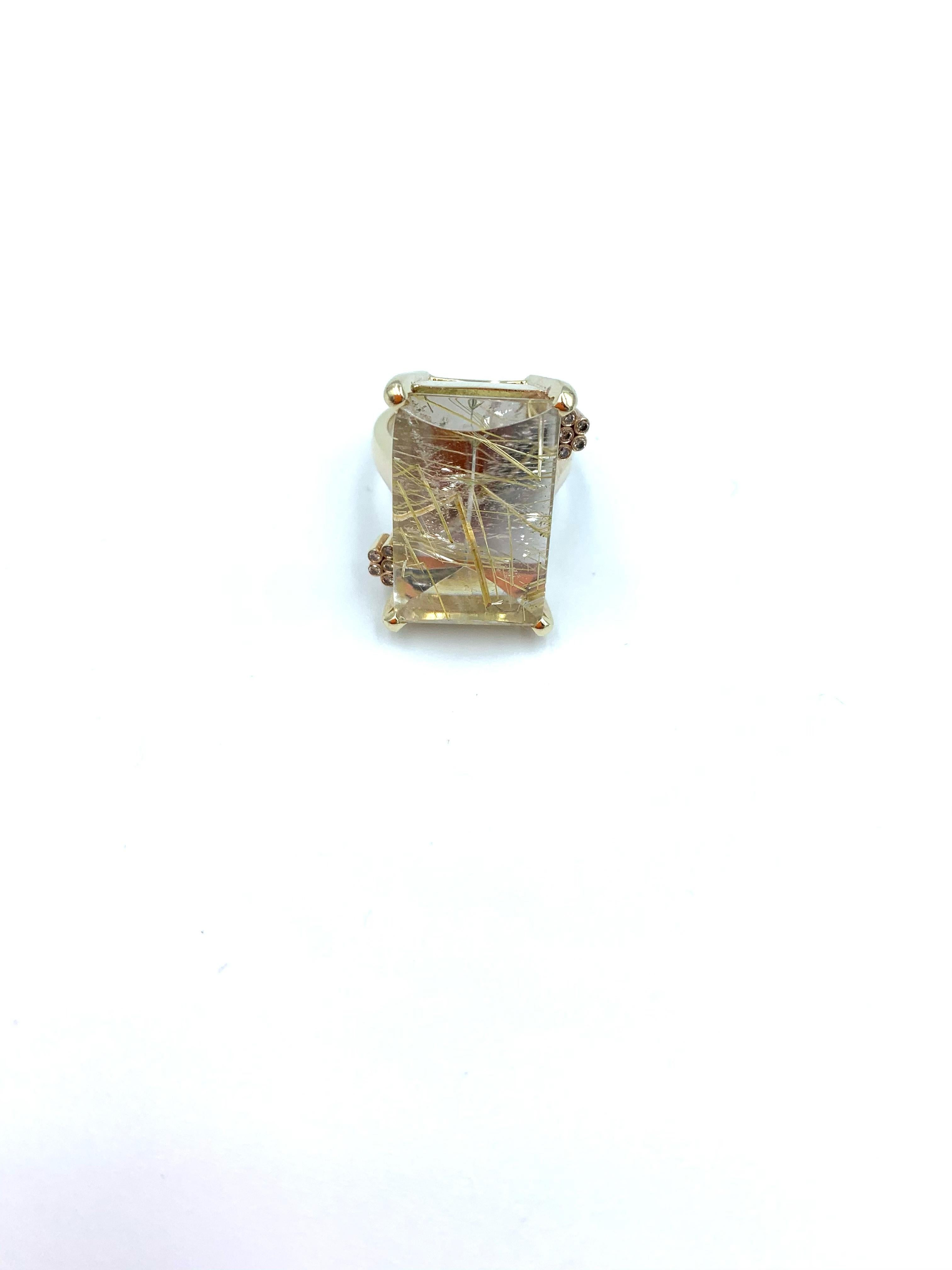 Handmade in 9 carat yellow gold, this stunning ring was created using a 26 carat Rutilated Quartz as it's centrepiece, gemstone prized by its unique inclusions, surrounding it with 5 small diamond accents to each side (approximately .1 carat in