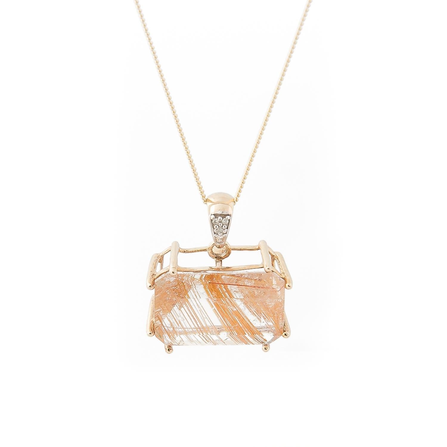 Vintage 9 K gold pendant with large emerald cut Rutilated Quartz in a horizontal basket setting, bail set with pave cut diamonds. Hallmarked Birmingham.

Rutilated quartz is a variety of quartz which contains acicular (needle-like) inclusions of
