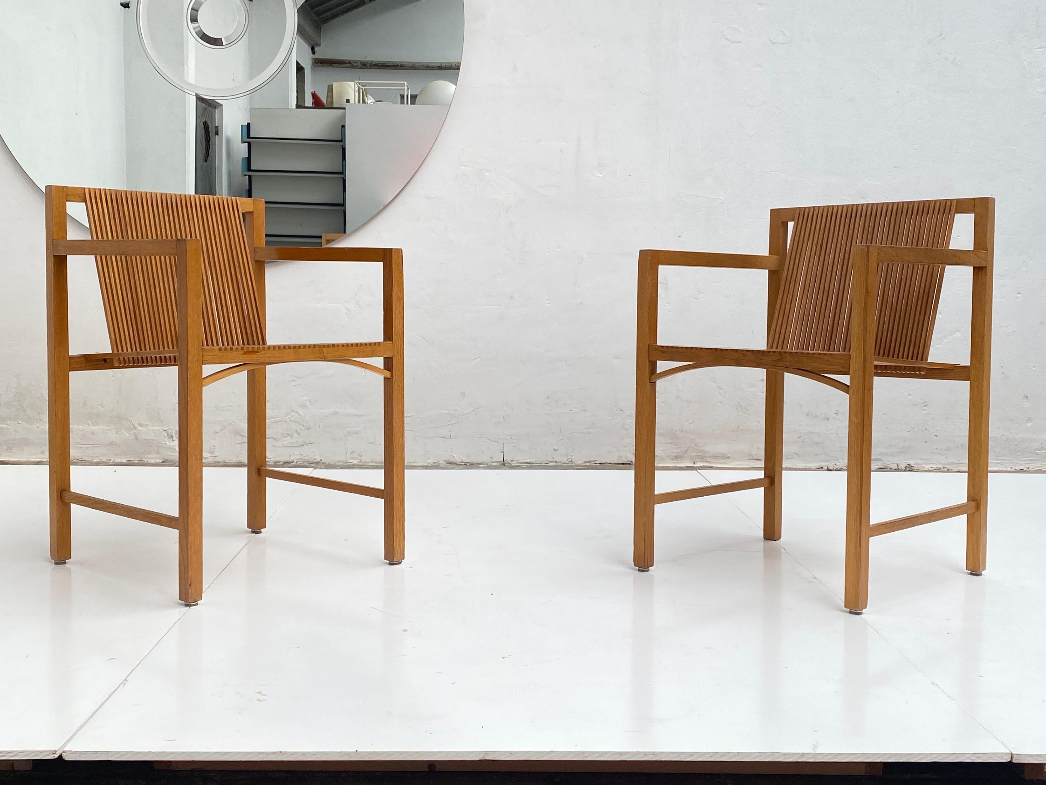 Designed by Ruud-Jan Kokke, these slat chairs were produced by the Dutch manufactory Spectrum, in 1986 as part part of their series called “Kokke-Chairs”. 

This pair’s frames are manually assembled and are made of oak, while the resilient slats