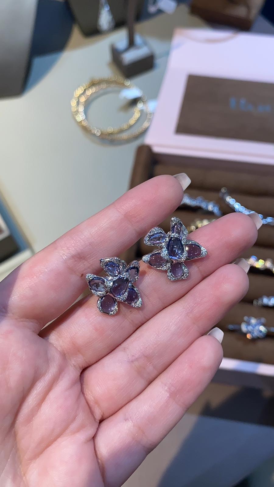 A delicate masterpiece of craftsmanship, this white Gold Petal earrings embodies elegance and femininity. Designed with an organic, sculptural form, these earrings   features a stunning floral motif at its center, adorned with  Blue sapphires that