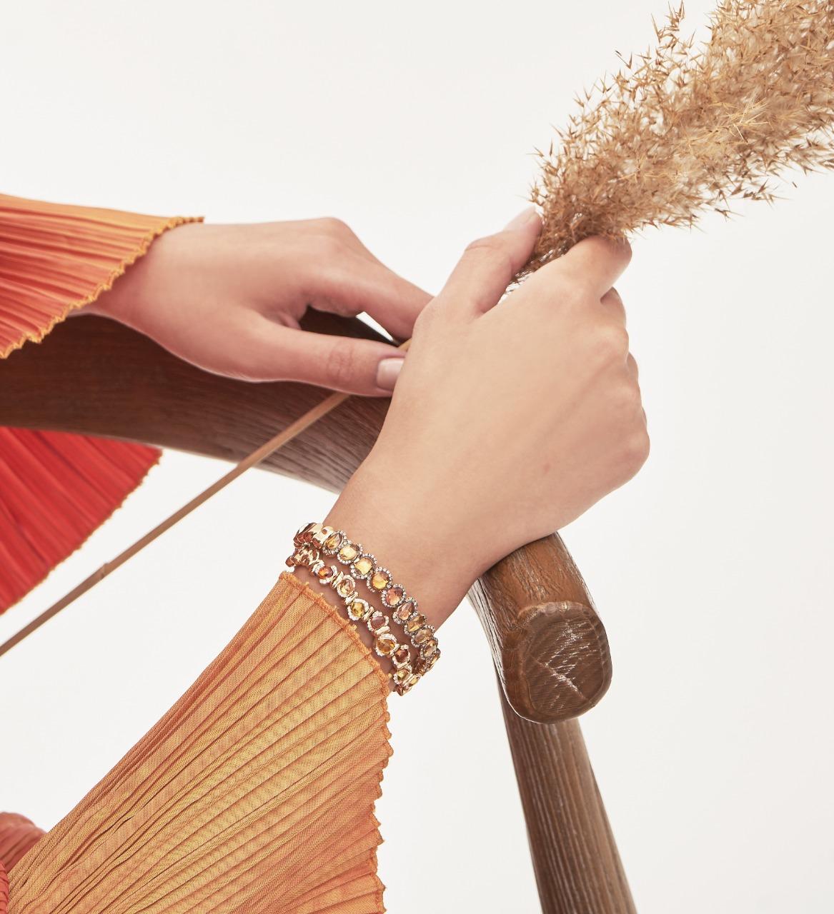18K Yellow Gold Bracelet with Orange Sapphires and Round-Cut Diamonds

Radiating warmth and elegance, this exquisite bracelet is crafted in 18K yellow gold and adorned with a vibrant gradient of brown  sapphires. Each sapphire is beautifully