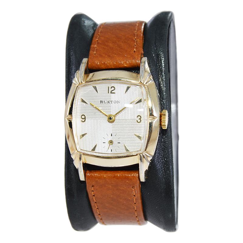 FABRIK / HAUS: Ruxton Watch Company
STIL / REFERENZ: Art Deco / Kissen Form
METALL / MATERIAL: Gelbgold gefüllt
CIRCA / JAHR: 1940er Jahre
ABMESSUNGEN / GRÖSSE: 34mm x 28mm
UHRWERK / KALIBER: Handaufzug / 17 Jewels 
ZIFFERBLATT / ZEIGER: Original