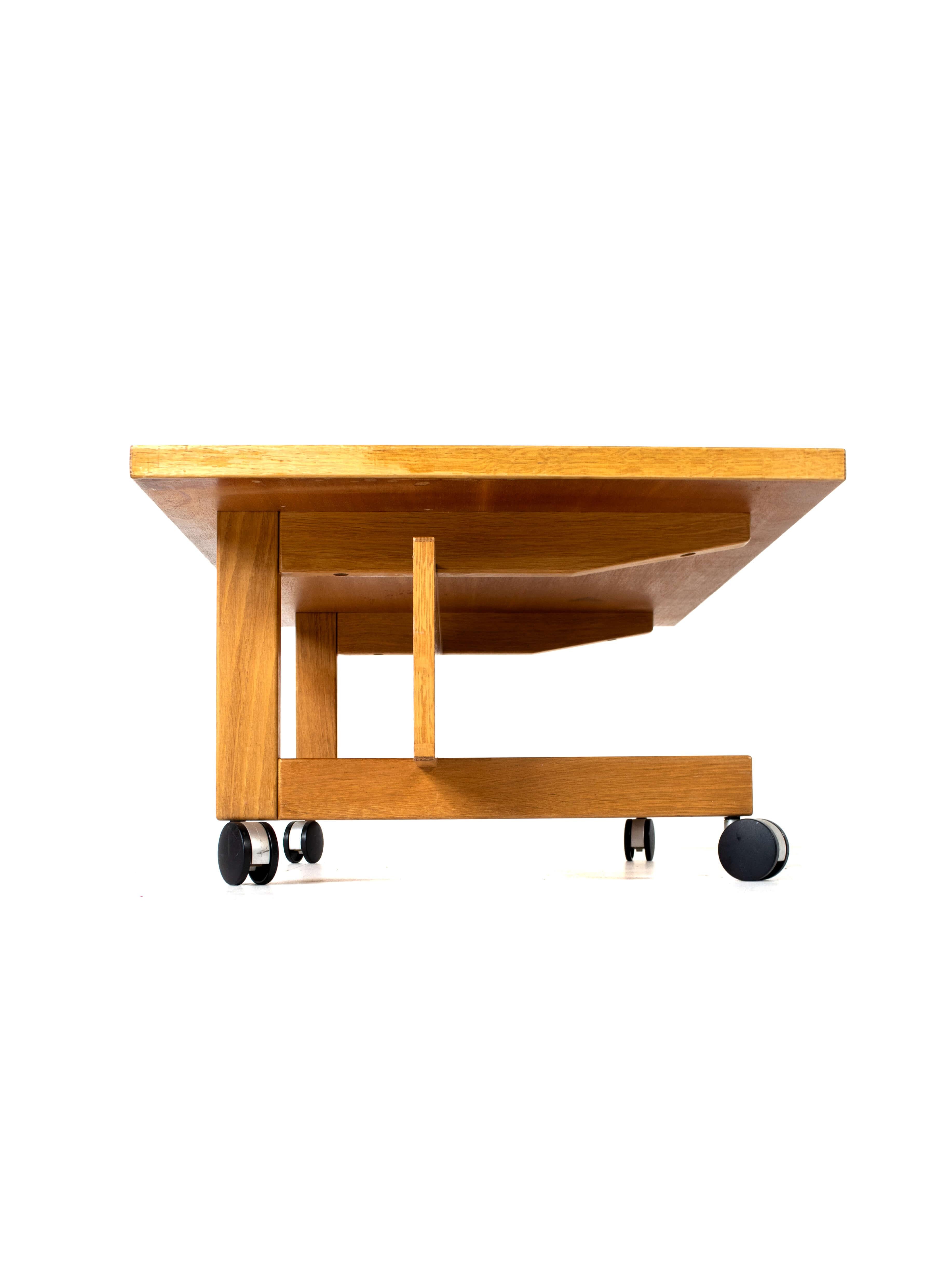 RY 100 coffee table by Hans Wegner for RY Møbler, Denmark 1980. This coffee table has a true minimalistic Danish Design. It is practical due to its wheels and ideal to combine with a Danish Sofa. The combination of horizontal and vertical wooden