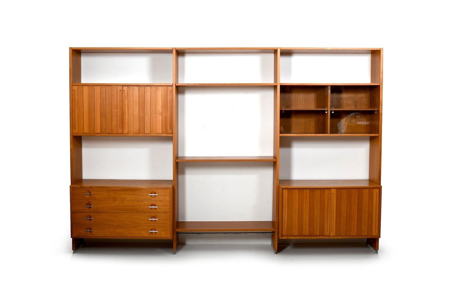 Danish wall unit in teak. Designed by Hans J.Wegner. Manufactured by Ry Møbler. Model RY-100, Denmark, 1960s. The wall unit consists of 4 cabinets (inside with shelves, one with glass doors and one drawer cabinet) and a middle part with just with